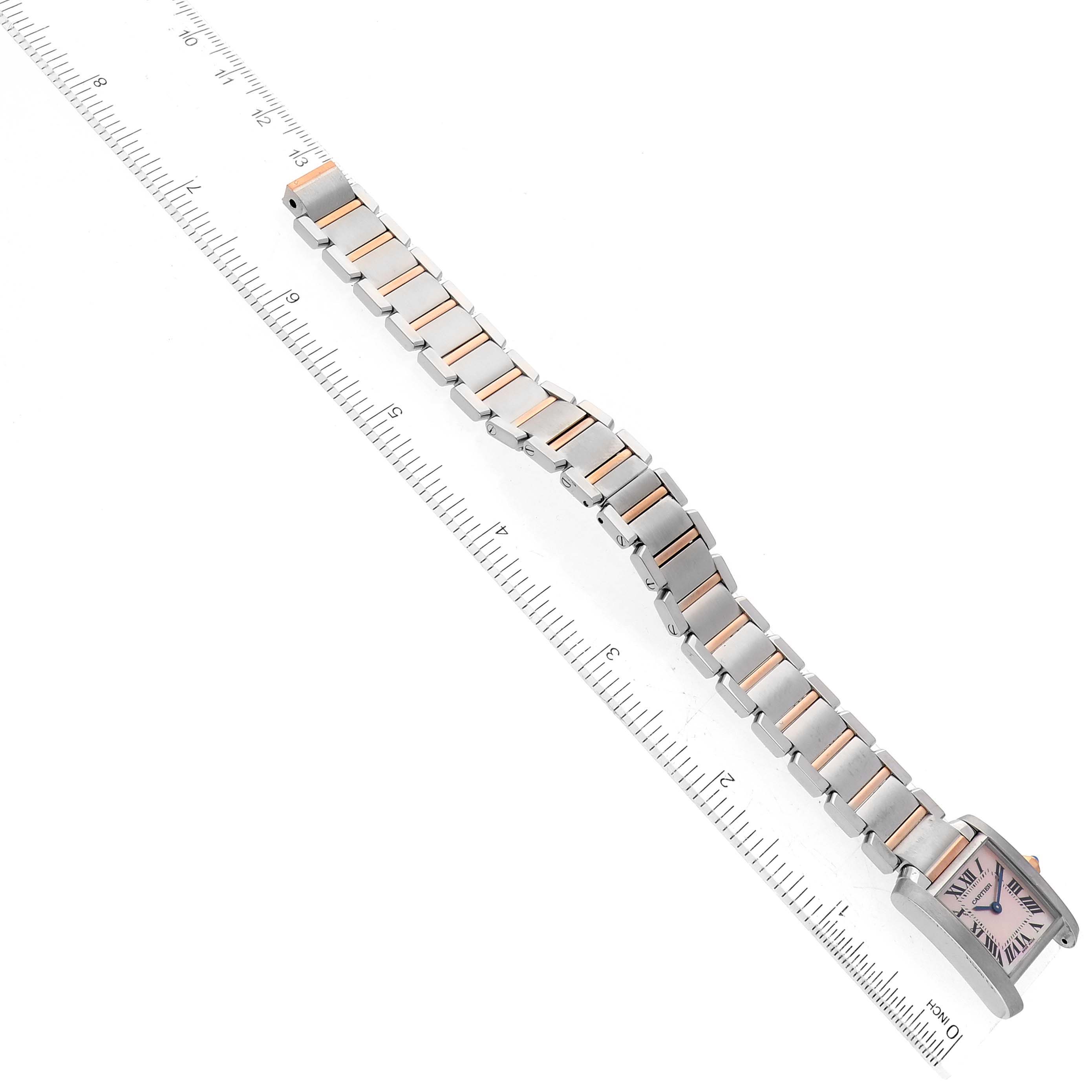 The image shows a Cartier Tank Française watch from an overhead angle, displaying the entire band and face alongside a ruler.