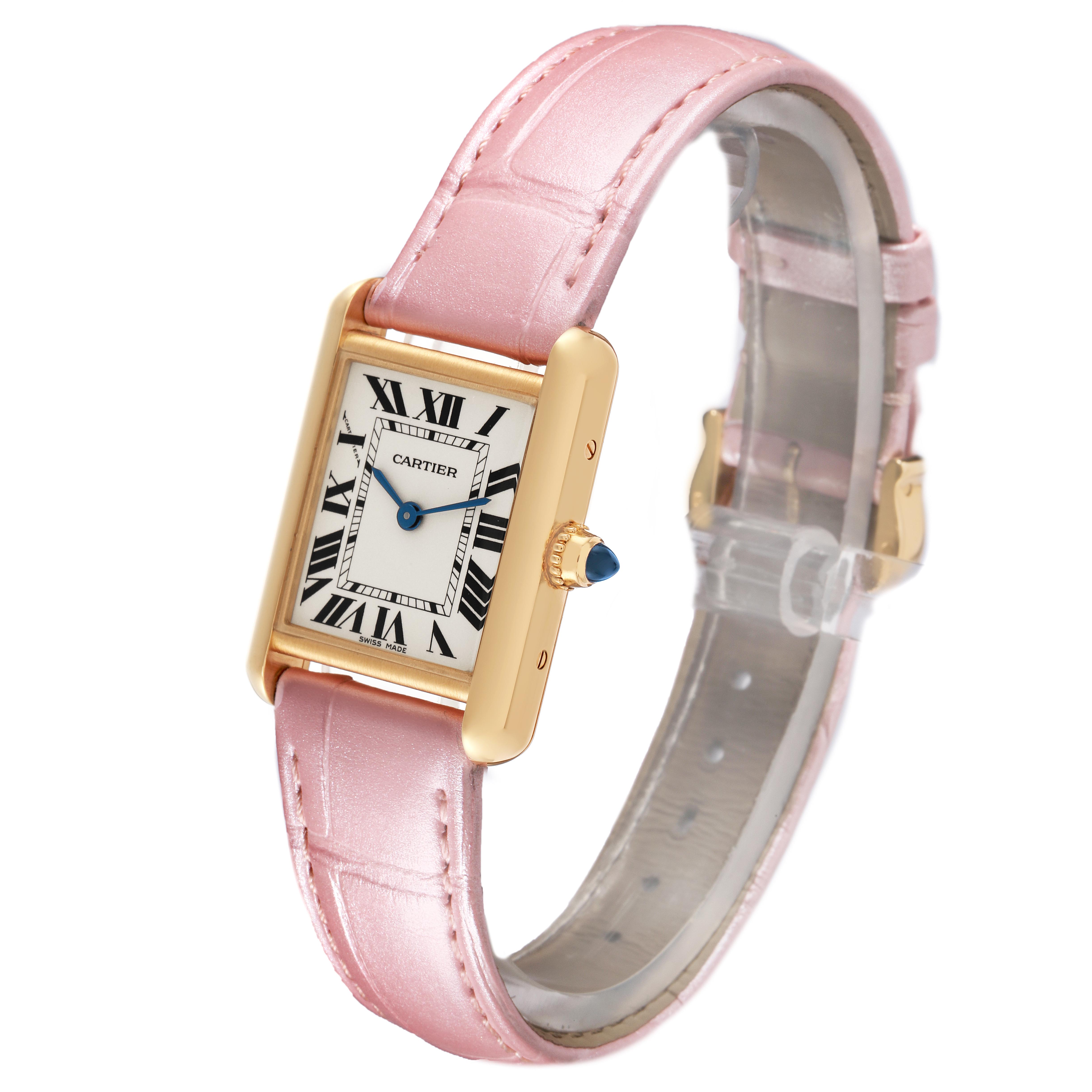 The Cartier Tank Louis W1529856 Women's Yellow Gold Silver Dial W1529856 Women's Yellow Gold Silver Dial watch is shown at an angle highlighting the face, pink leather strap, and the gemstone on the crown.