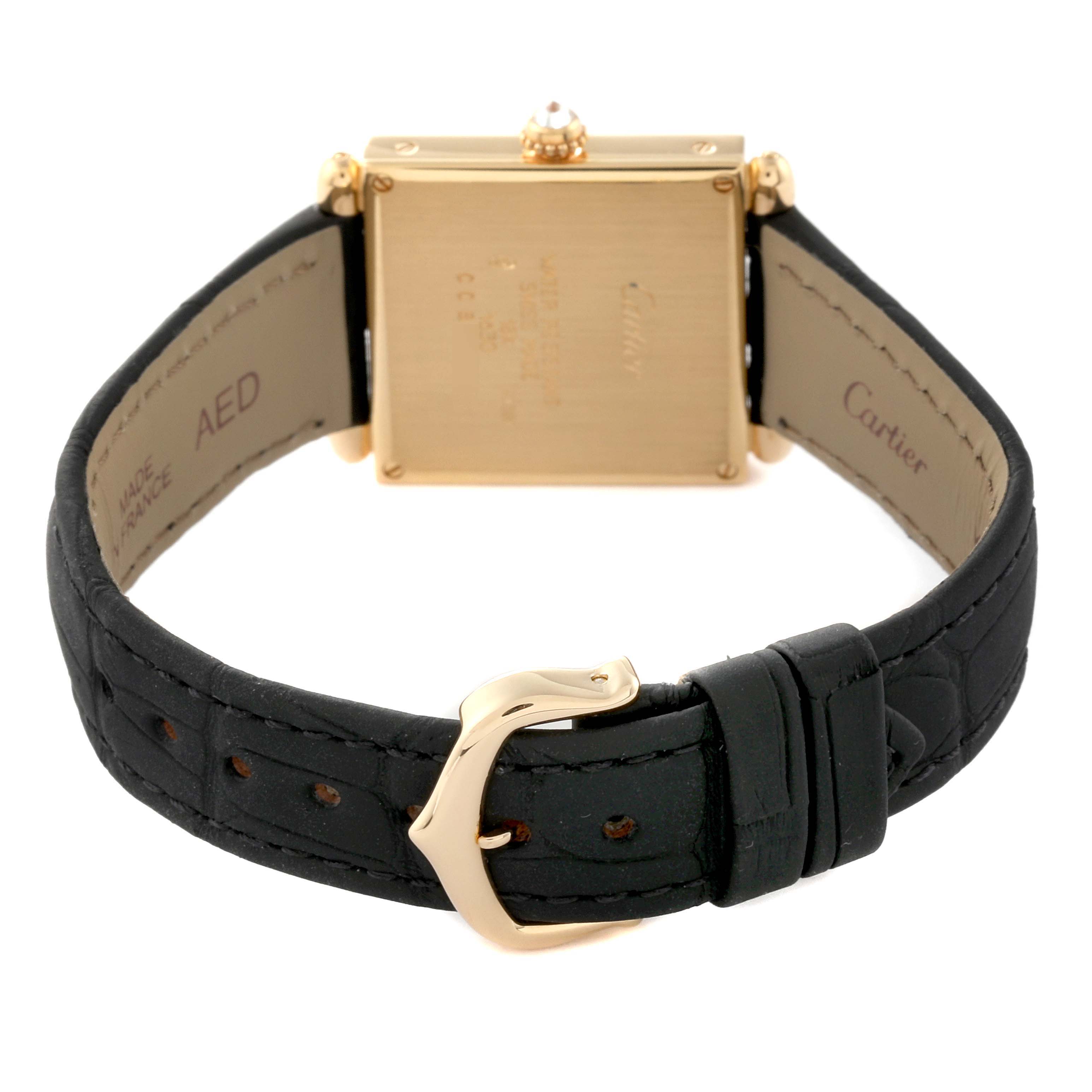 The image shows the back of the Tank Obus watch by Cartier, highlighting its square case, black leather strap, and gold buckle.