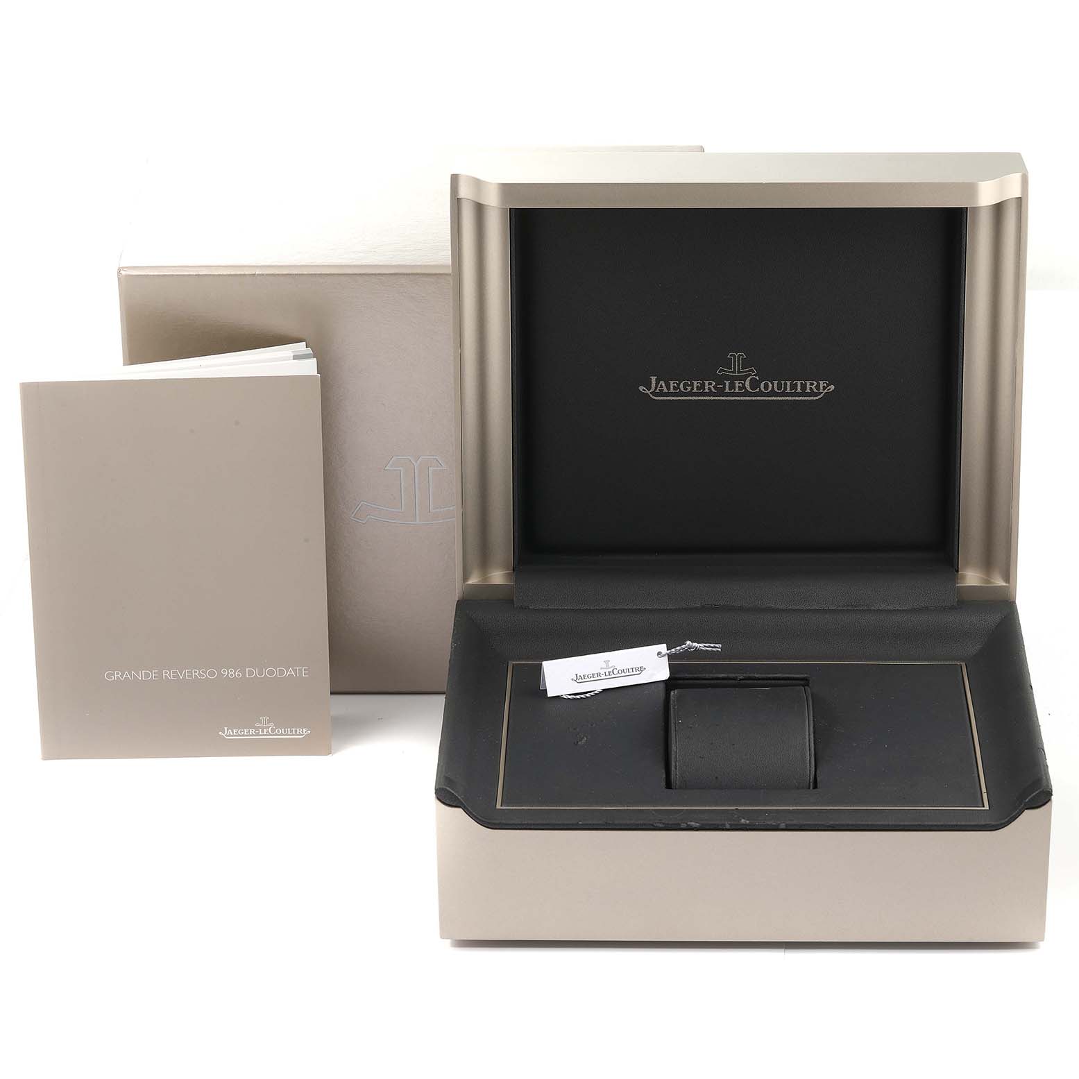 The image shows the packaging, box, and manual for the Jaeger-LeCoultre Reverso watch model.
