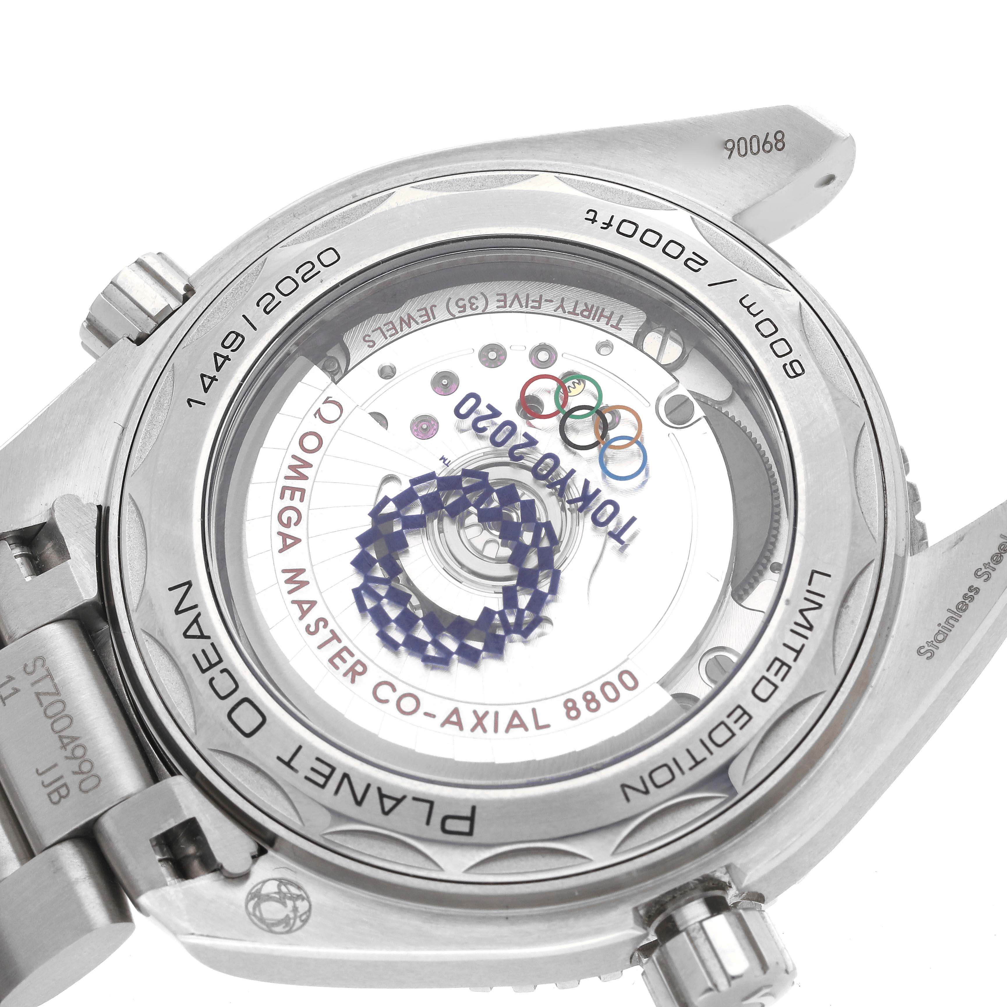 The image shows the back of an Omega Planet Ocean 522.33.40.20.04.001 Men
s Stainless Steel White Dial 522.33.40.20.04.001 Men
s Stainless Steel White Dial watch, displaying the inner workings and "Tokyo 2020" inscription.