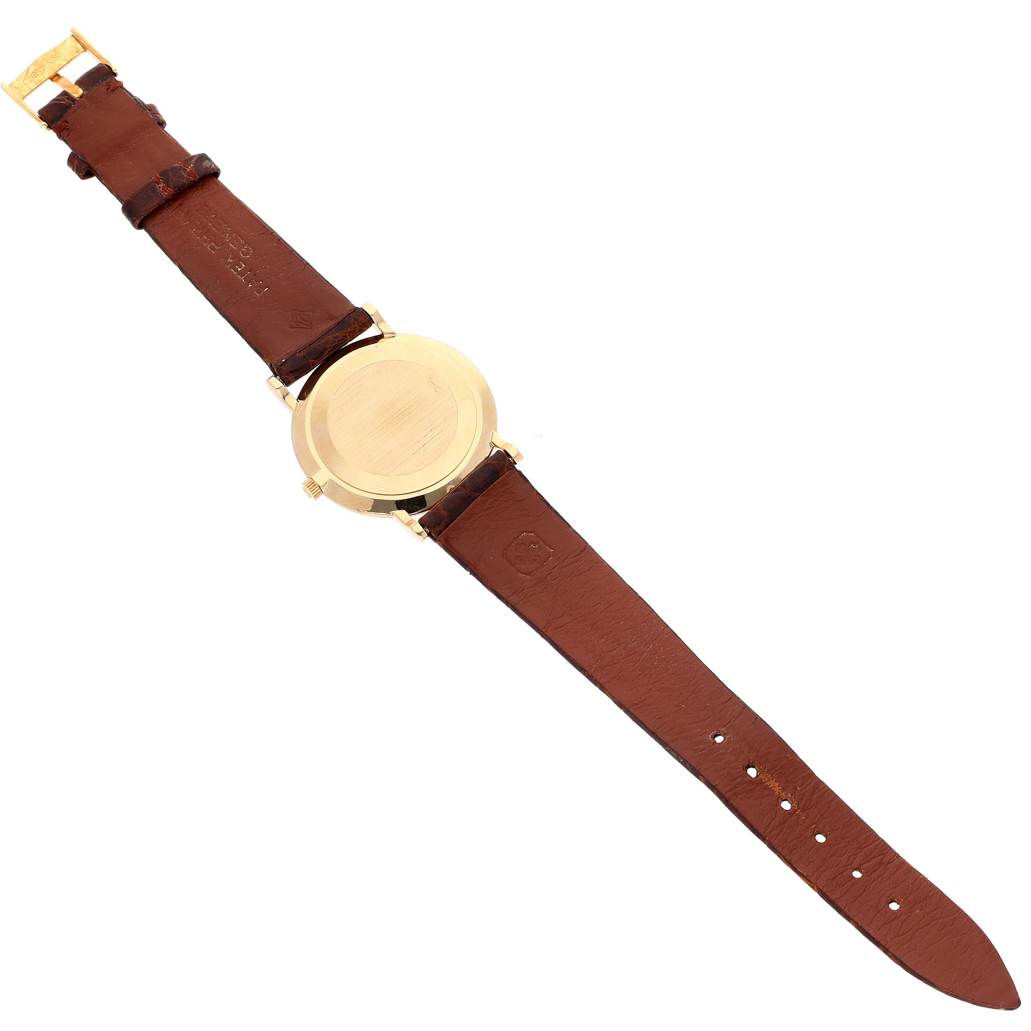 The image shows the back view of a Patek Philippe Calatrava 3919J Men's Yellow Gold White Dial 3919J Men's Yellow Gold White Dial watch with a brown leather strap.