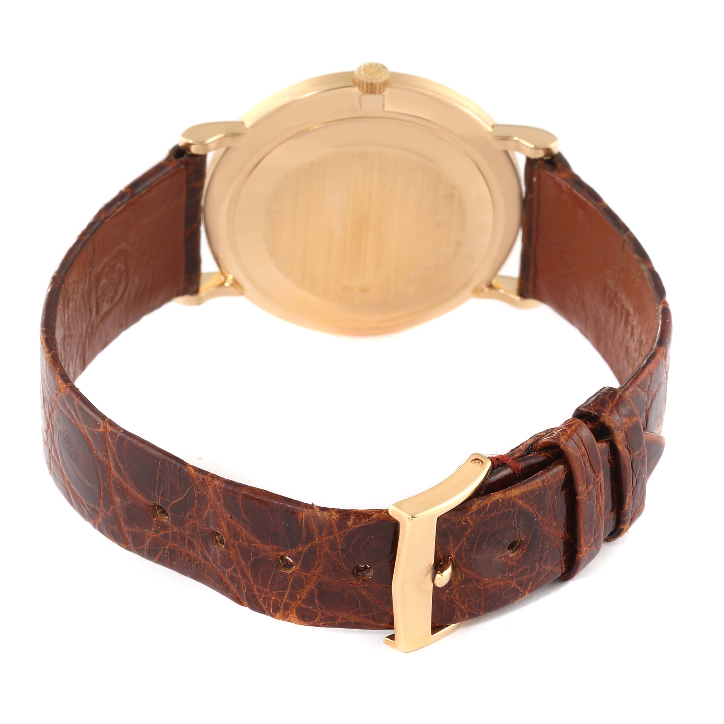 The image shows the back view of a Patek Philippe Calatrava 3919J Men's Yellow Gold White Dial 3919J Men's Yellow Gold White Dial watch, highlighting the gold case and brown leather strap with a buckle.