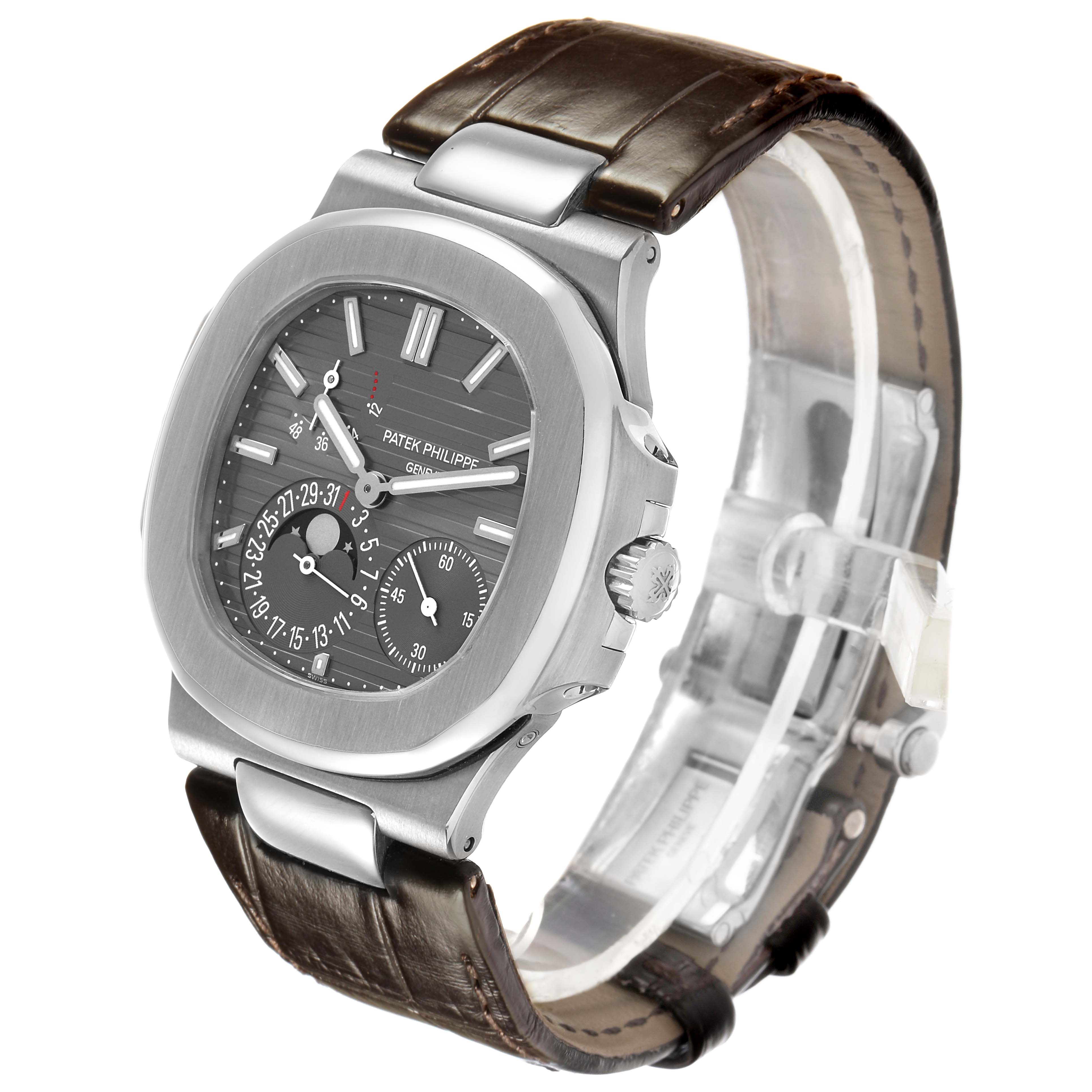 The Patek Philippe Nautilus 5712G-001 Men's White Gold Grey Dial watch is shown at a three-quarter angle, featuring its dial, case, and leather strap.