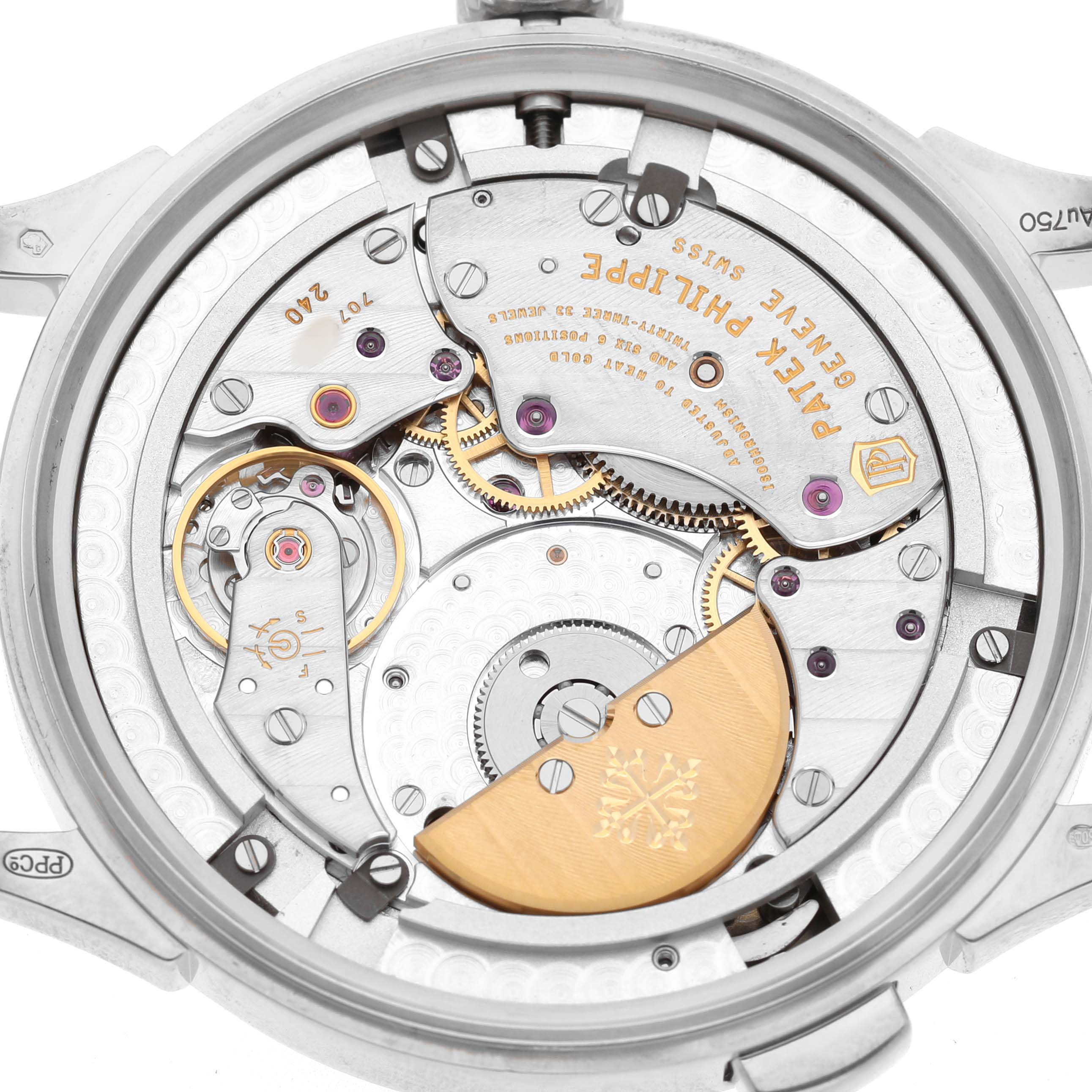 The image shows the movement of a Patek Philippe Complications 5230G-001 Men's White Gold Grey Dial watch from a back angle, highlighting gears and the rotor.