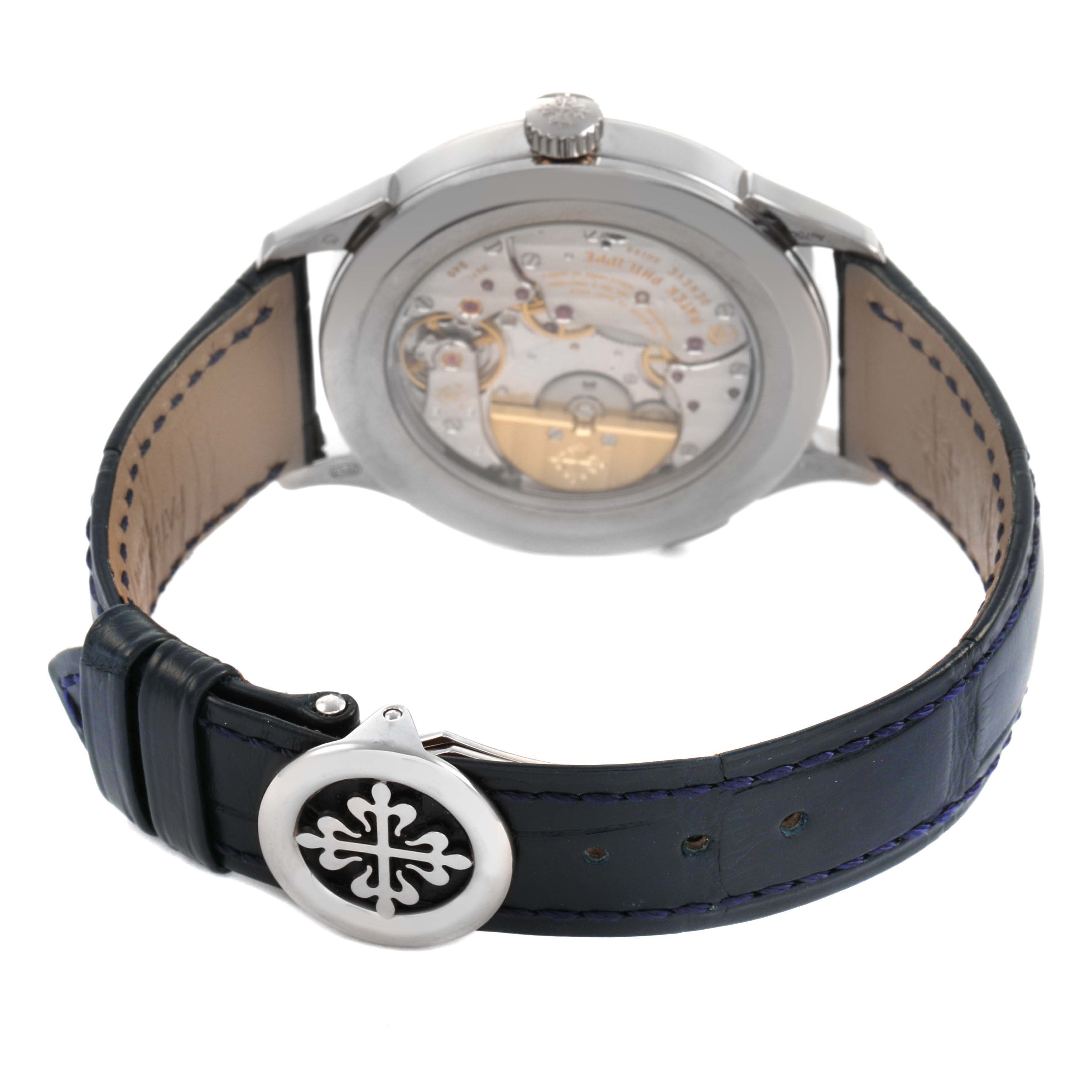 The image shows the back angle of a Patek Philippe Complications 5230G-001 Men's White Gold Grey Dial watch, highlighting the movement and the leather strap with clasp.