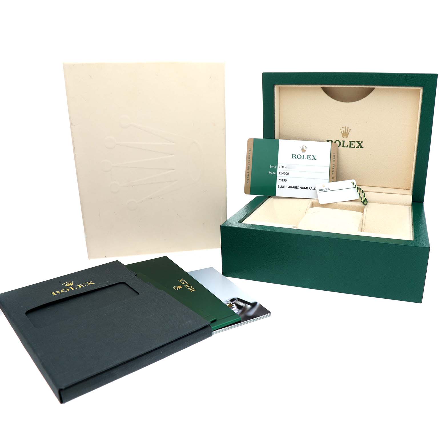 The image shows the packaging and accessories of a Rolex Oyster Perpetual 114200 Men's Stainless Steel Blue Dial, including the green box, card, and booklet.