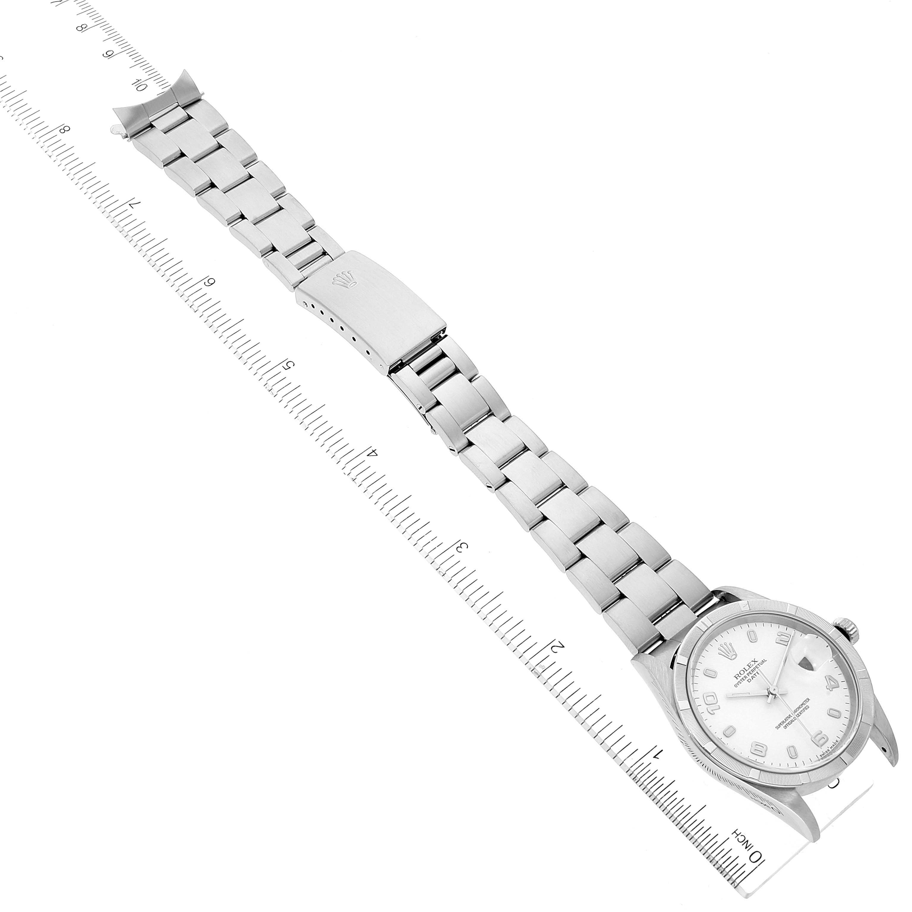 The image shows a Rolex Date 15210 Men's Stainless Steel White Dial 15210 Men's Stainless Steel White Dial model watch lying flat with its metal bracelet fully extended, alongside a ruler for scale.