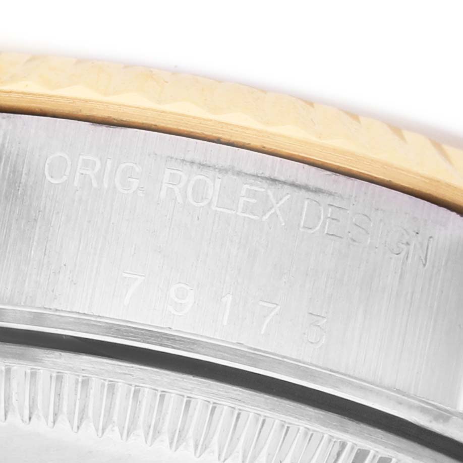 The image shows a close-up of the side of a Rolex Datejust 79173 Women's Steel and Gold (two tone) Silver Dial, highlighting the engraved serial and model numbers.