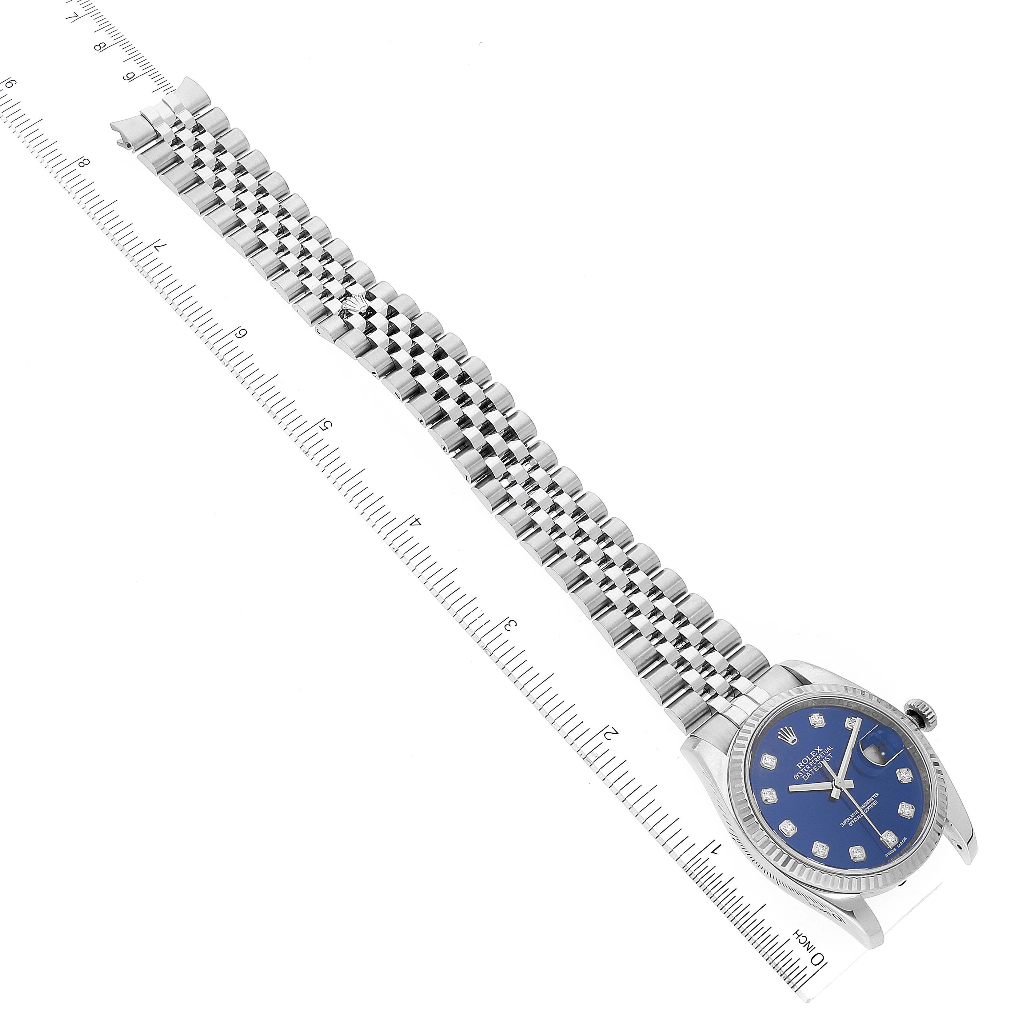 The image shows a Rolex Datejust 116234 Men's Stainless Steel Blue Dial 116234 Men's Stainless Steel Blue Dial watch from a top-down angle, featuring its blue dial, bezel, and metal bracelet next to a ruler.
