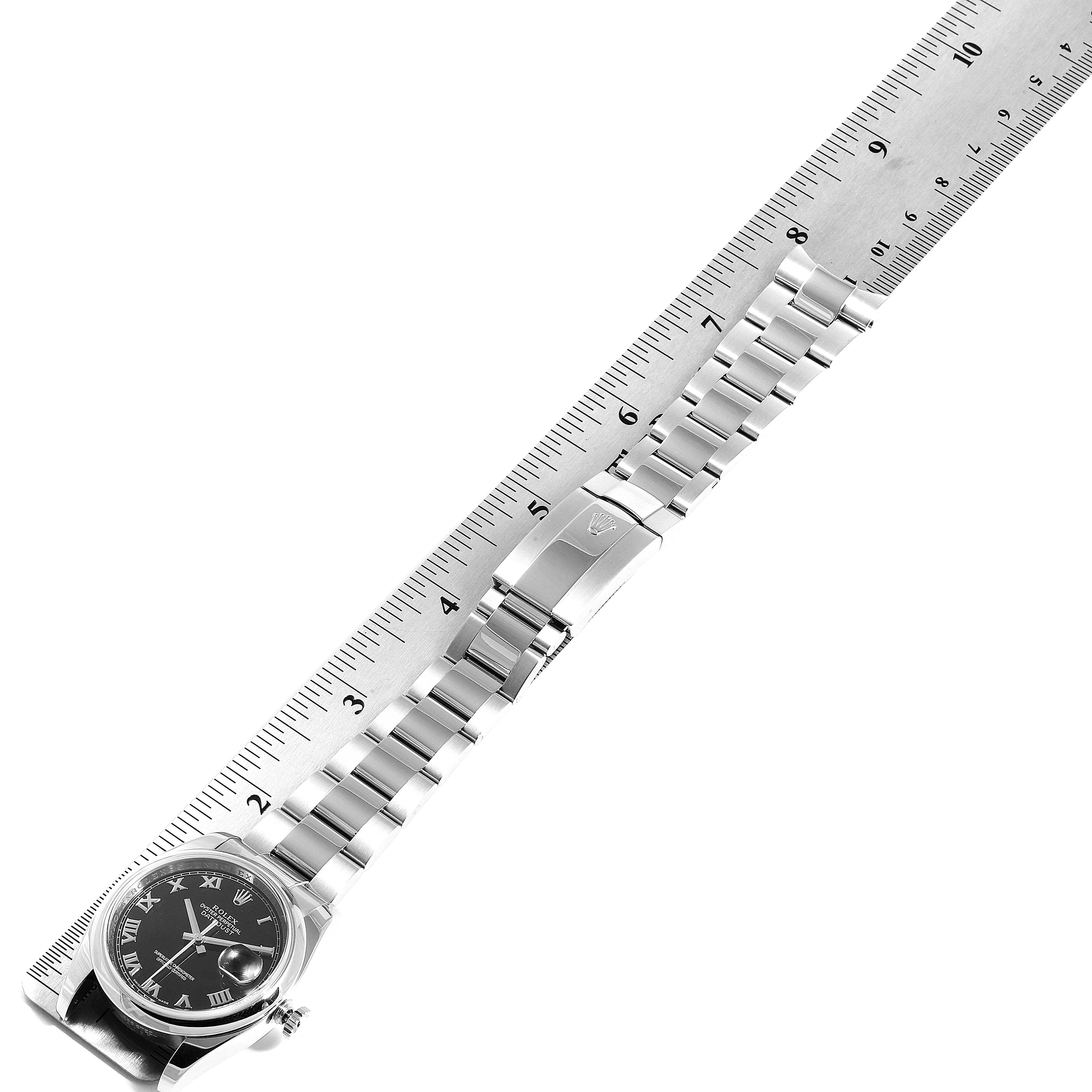 The image shows a Rolex Datejust 116200  Men's Stainless Steel Black Dial 116200  Men's Stainless Steel Black Dial watch laid flat with a metal ruler placed adjacent to measure its length.