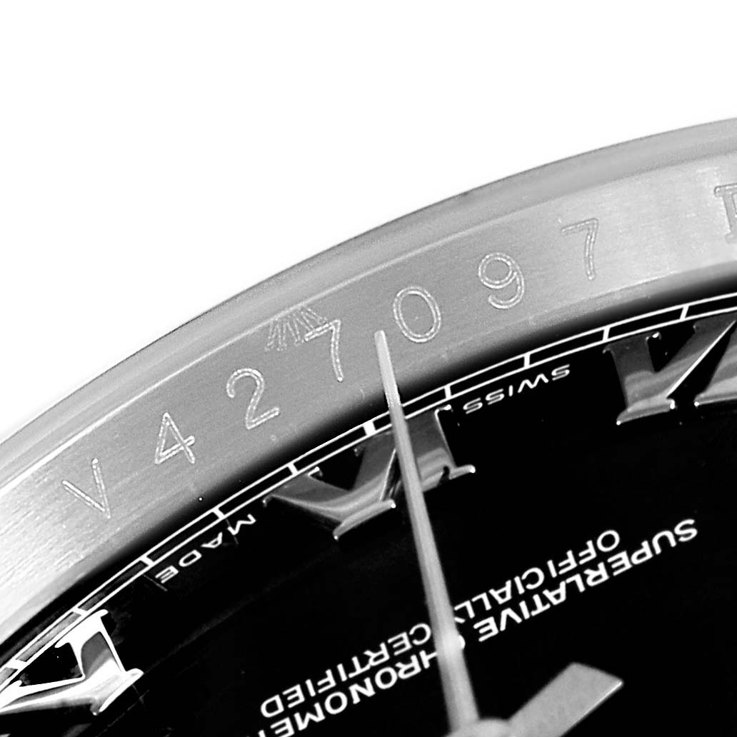 This image shows a close-up angle of the serial number engraving and part of the dial of a Rolex Datejust 116200  Men's Stainless Steel Black Dial 116200  Men's Stainless Steel Black Dial watch.
