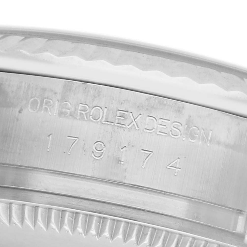 The image shows a close-up of the side of a Rolex Datejust 179174 Women's Stainless Steel White Dial 179174 Women's Stainless Steel White Dial watch, focusing on the engraved serial and design numbers.