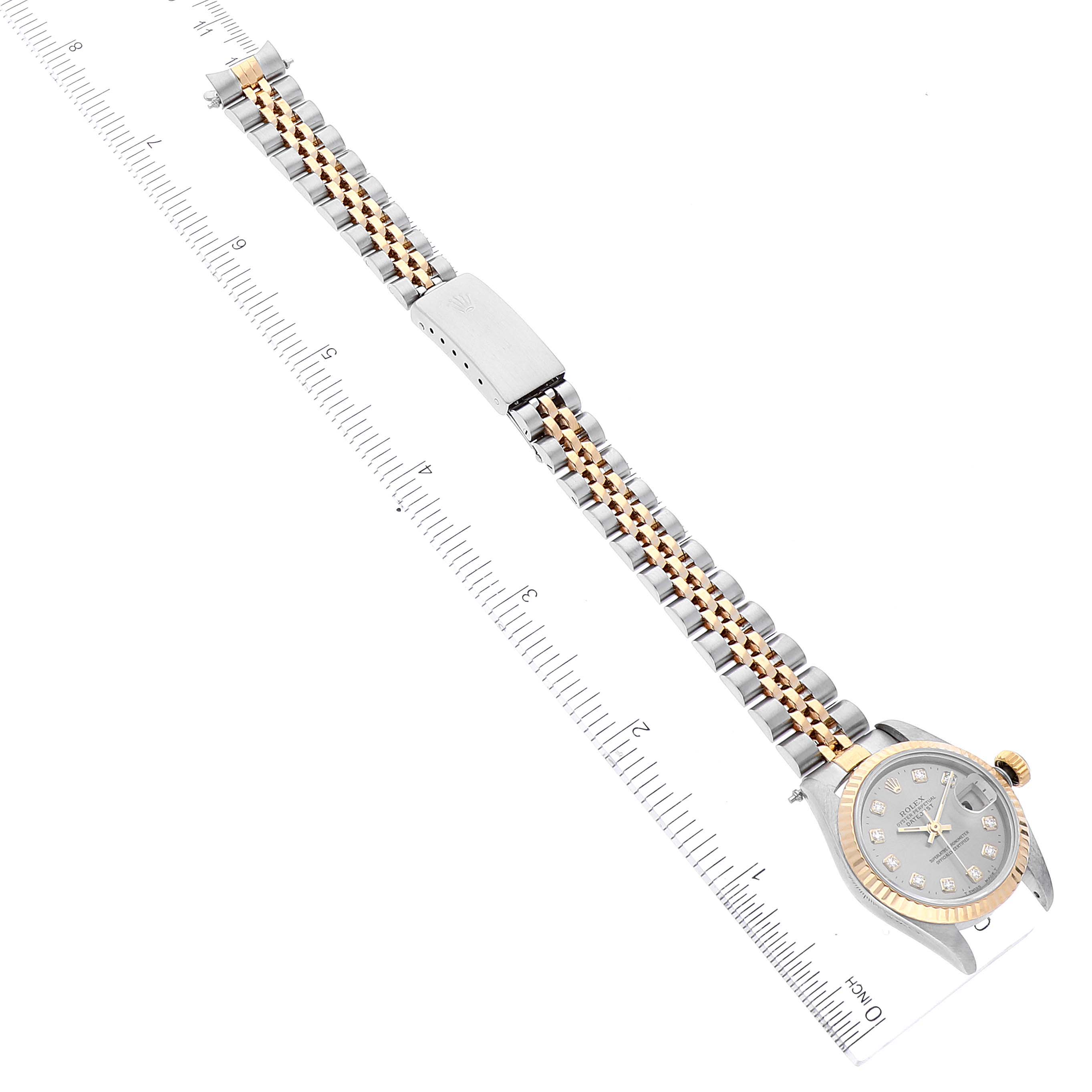 The image shows a top-down view of a Rolex Datejust 69173 Women
s Steel and Gold (two tone) Grey Dial 69173 Women
s Steel and Gold (two tone) Grey Dial watch, displaying its face, bezel, bracelet, and clasp alongside a ruler.