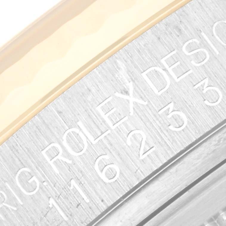 This image shows a close-up of the outer rim of the watch dial, featuring part of the model number and "ROLEX DESIGN" engraving on a Rolex Datejust 116233 Men's Steel and Gold (two tone) Silver Dial 116233 Men's Steel and Gold (two tone) Silver Dial.