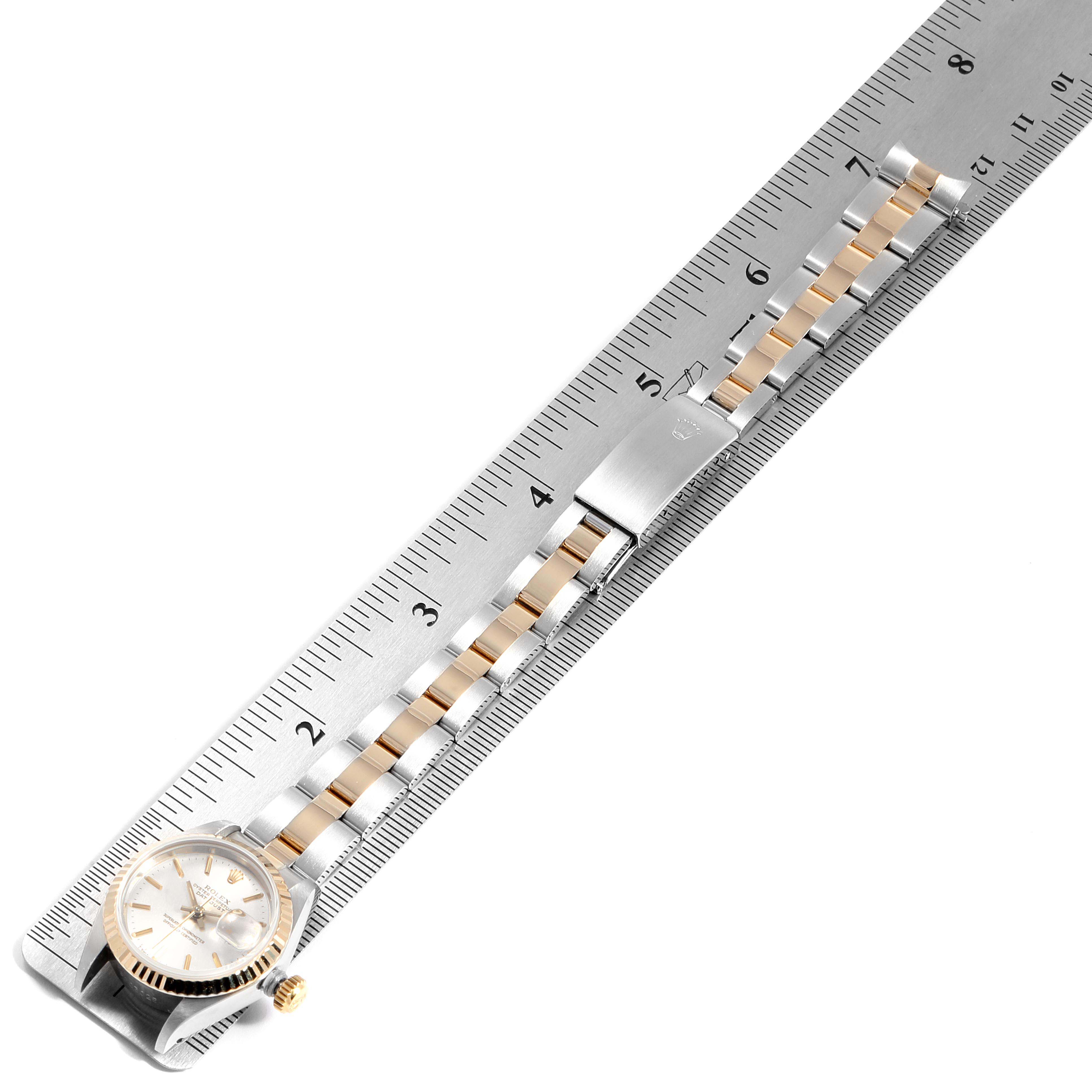 The Rolex Datejust 69173 Women
s Steel and Gold (two tone) Silver Dial 69173 Women
s Steel and Gold (two tone) Silver Dial watch is shown from an overhead angle, displaying the dial, bezel, bracelet, and clasp with a ruler for scale.