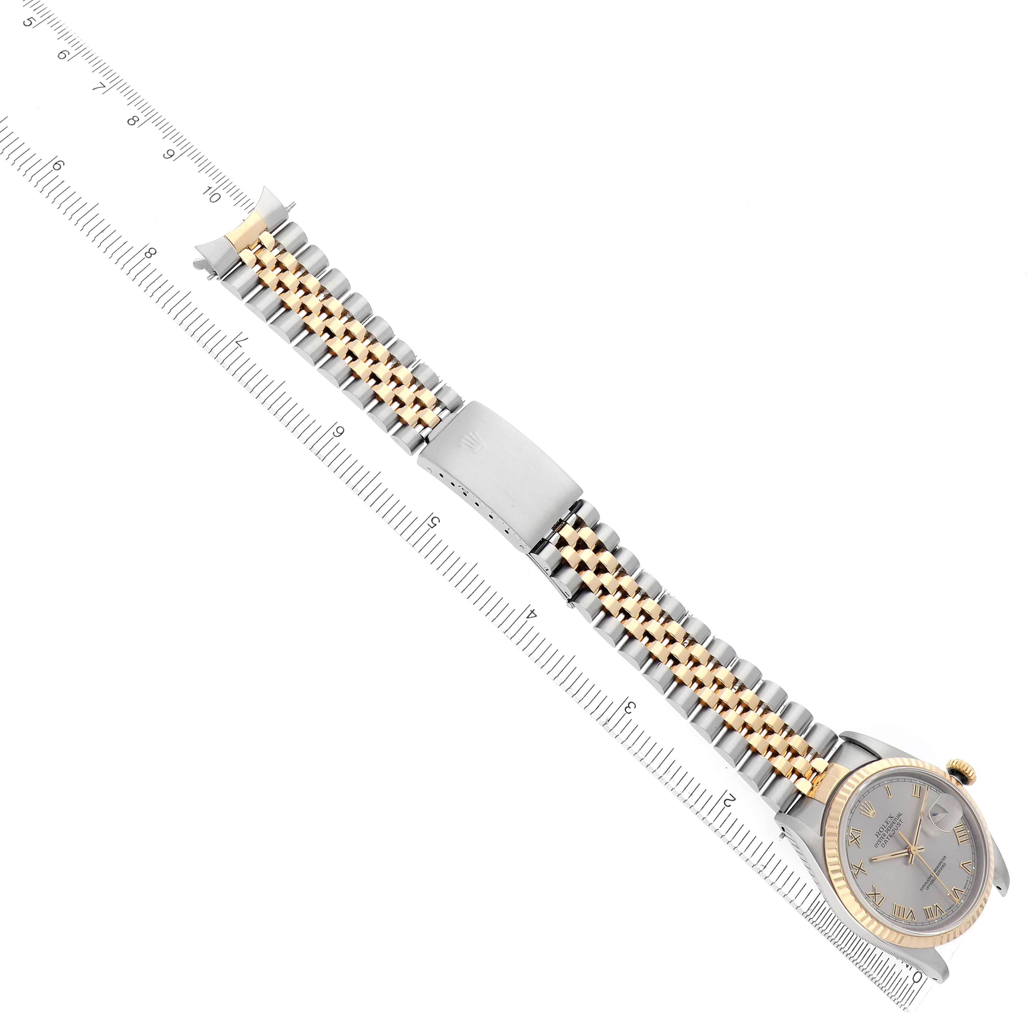 The image shows a top-down view of a Rolex Datejust 16233 Men's Steel and Gold (two tone) Silver Dial 16233 Men's Steel and Gold (two tone) Silver Dial watch, highlighting the face, bracelet, and clasp alongside a ruler.