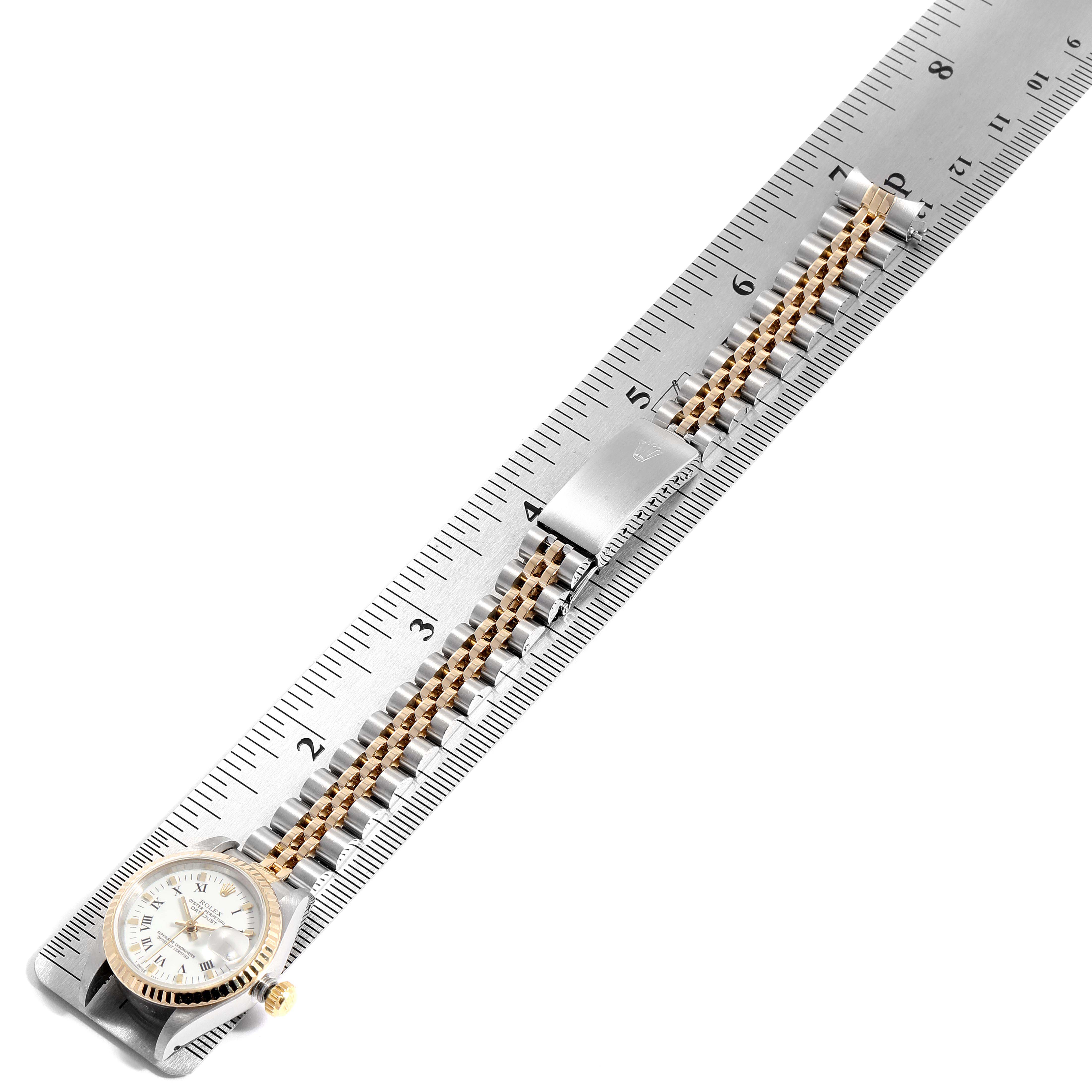 The image shows a Rolex Datejust 69173 Women
s Steel and Gold (two tone) White Dial 69173 Women
s Steel and Gold (two tone) White Dial watch laid flat along a ruler, highlighting the case, bracelet, and clasp.