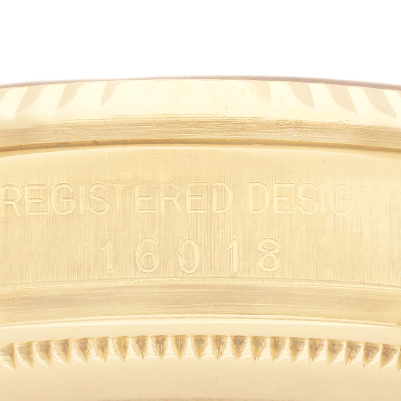 The image shows a close-up of the side of a Rolex Vintage Collection 16018 Men's Yellow Gold Champagne Dial 16018 Men's Yellow Gold Champagne Dial model, focusing on the "REGISTERED DESIGN 16018" engraving.