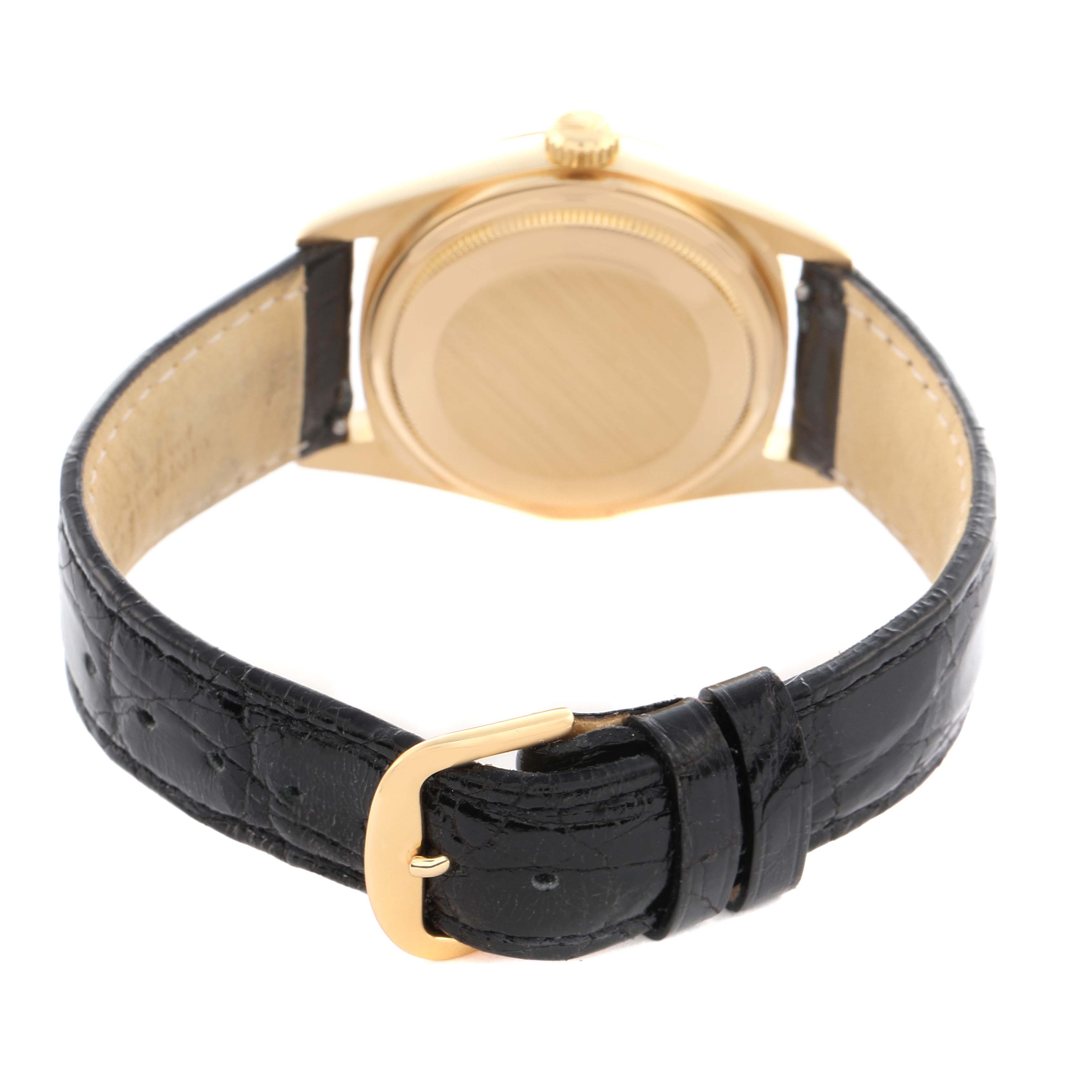 The Vintage Collection model by Rolex is shown from the back, highlighting the gold case, crown, and black leather strap with a buckle.