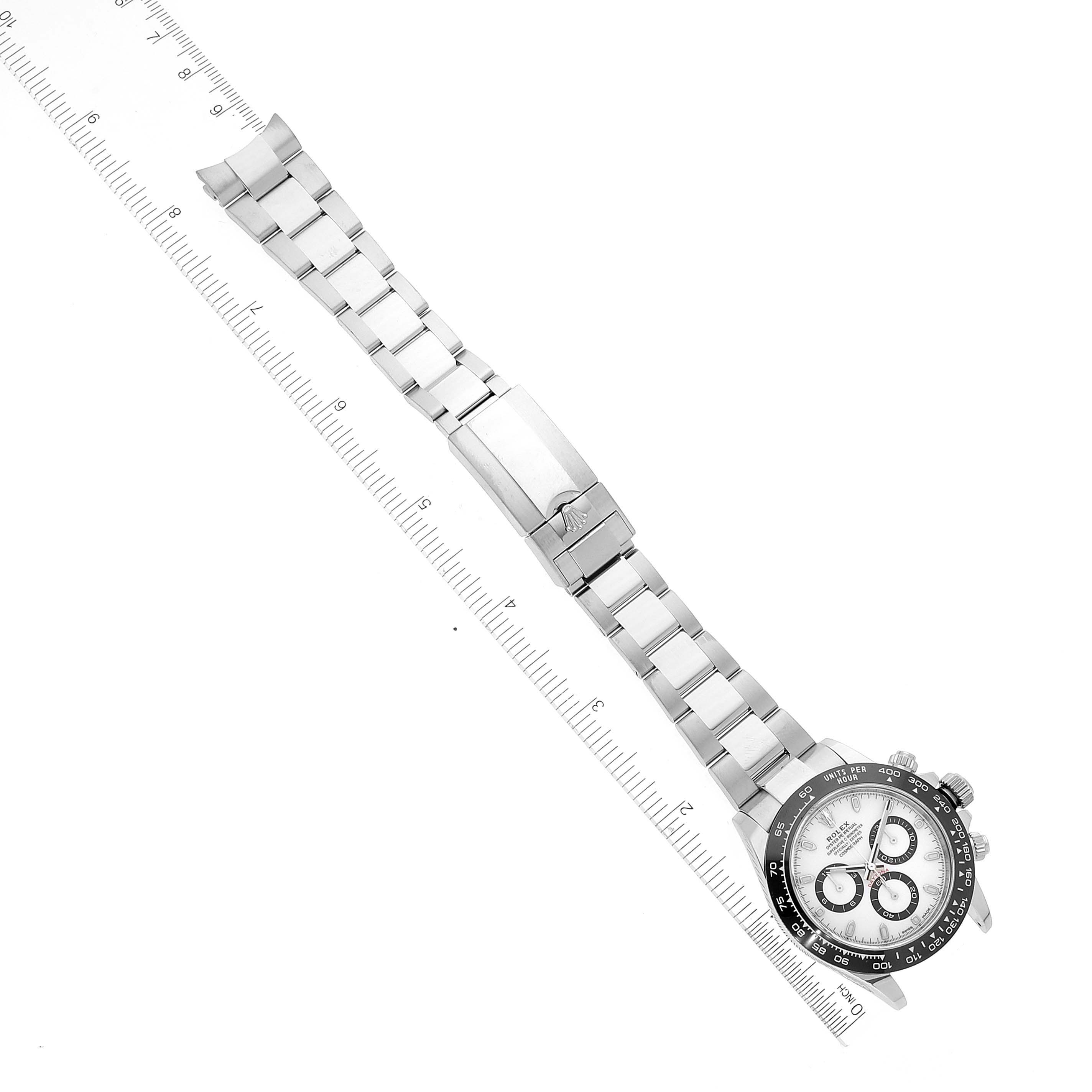 The Rolex Daytona 116500 Men's Stainless Steel Black Dial 116500 Men's Stainless Steel Black Dial watch is shown flat with its face and full bracelet visible along with a measuring ruler alongside it.