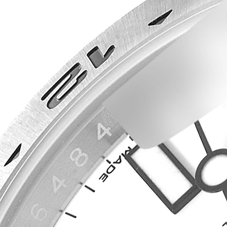 The image shows a close-up of the bezel and part of the dial and hands of a Rolex Explorer 216570 Men's Stainless Steel White Dial 216570 Men's Stainless Steel White Dial watch.
