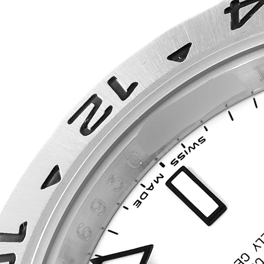This angled close-up of a Rolex Explorer 16570 Men's Stainless Steel White Dial 16570 Men's Stainless Steel White Dial watch shows part of the bezel and a portion of the dial with the "Swiss Made" text.