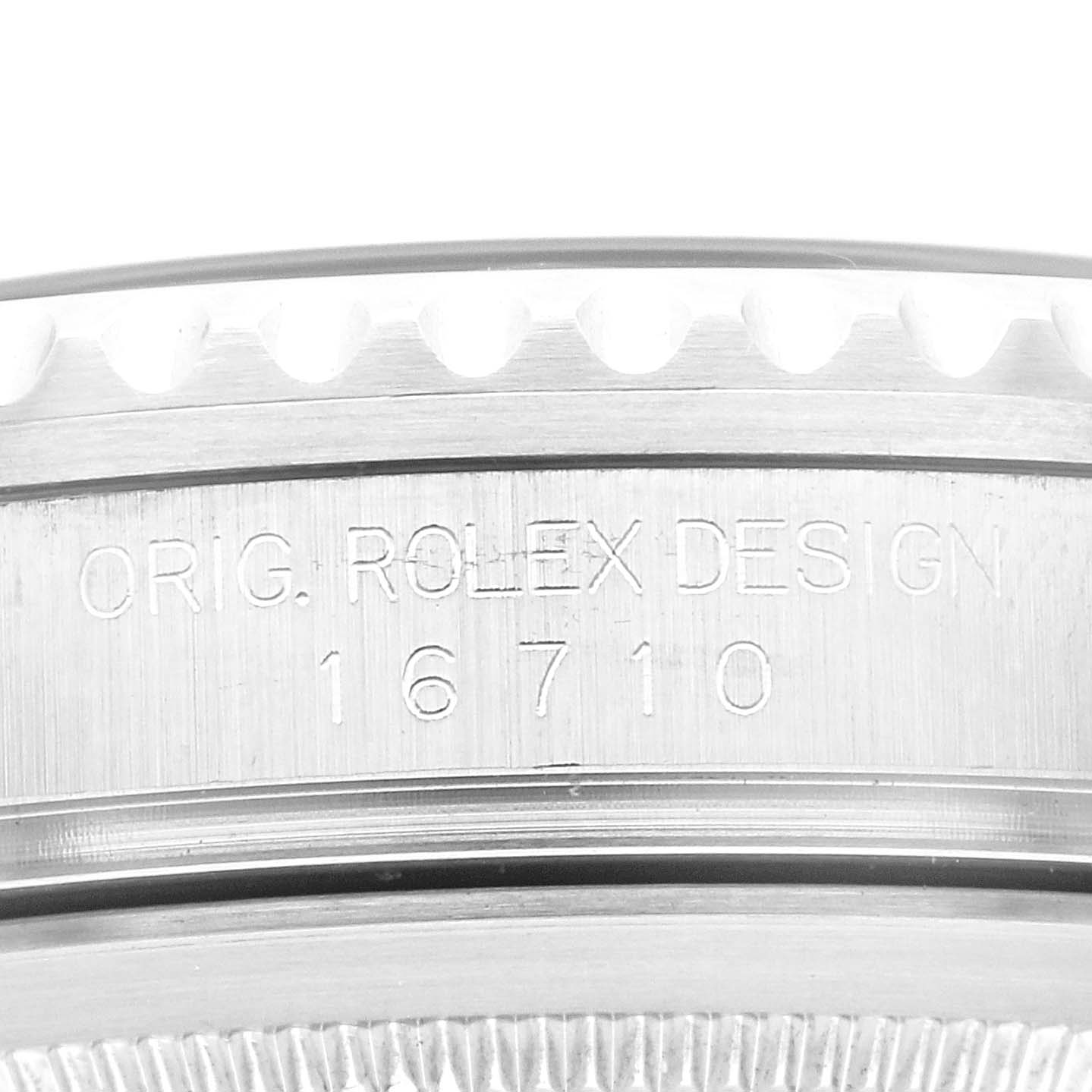 This image shows a close-up of the side of a Rolex GMT-Master 16710 Men
s Stainless Steel Black Dial 16710 Men
s Stainless Steel Black Dial watch case, revealing the model number 16710 and the text "ORIG. ROLEX DESIGN."