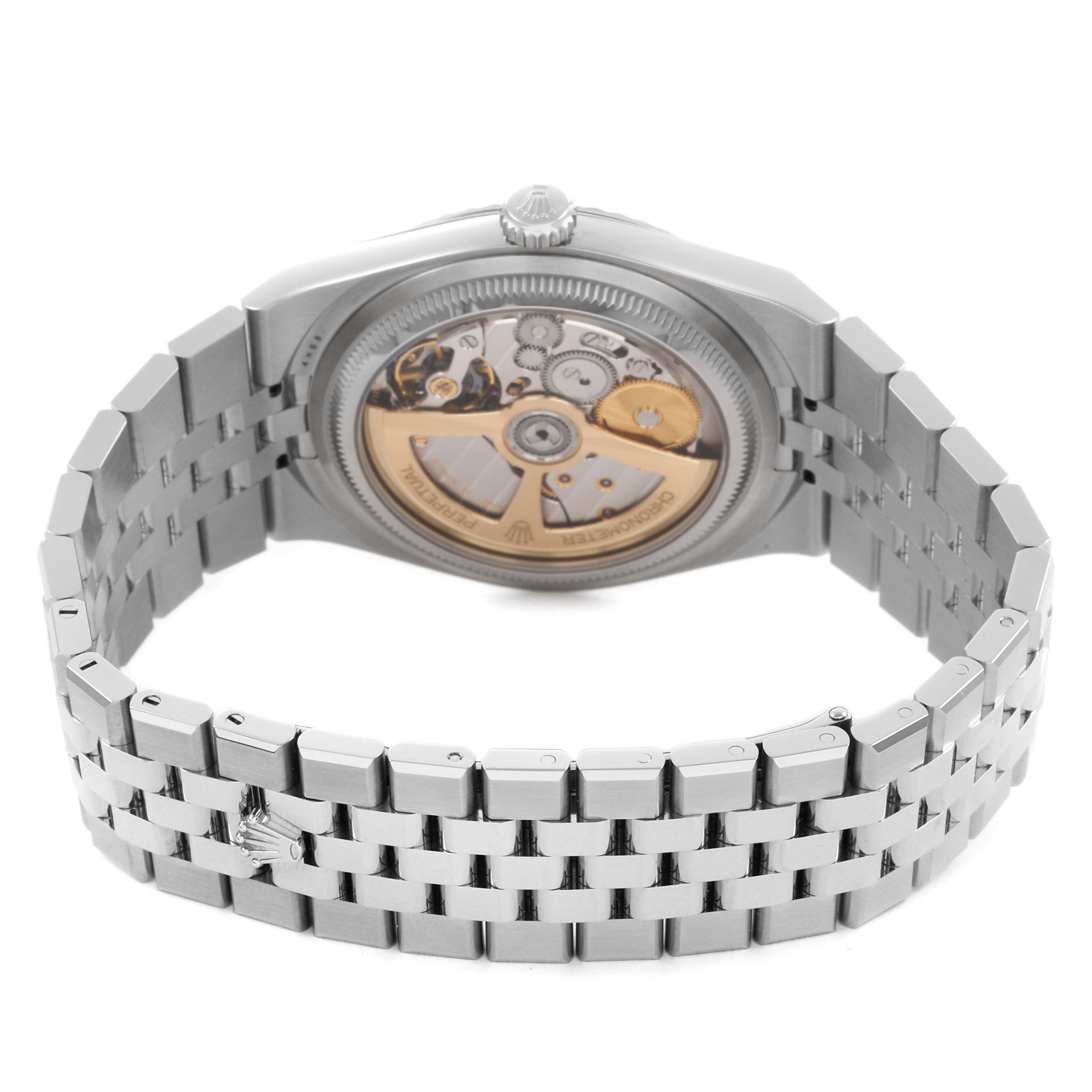 The Rolex Land‑Dweller 127334 Men's Stainless Steel White Dial watch is shown from the back, highlighting its exposed movement and silver bracelet.
