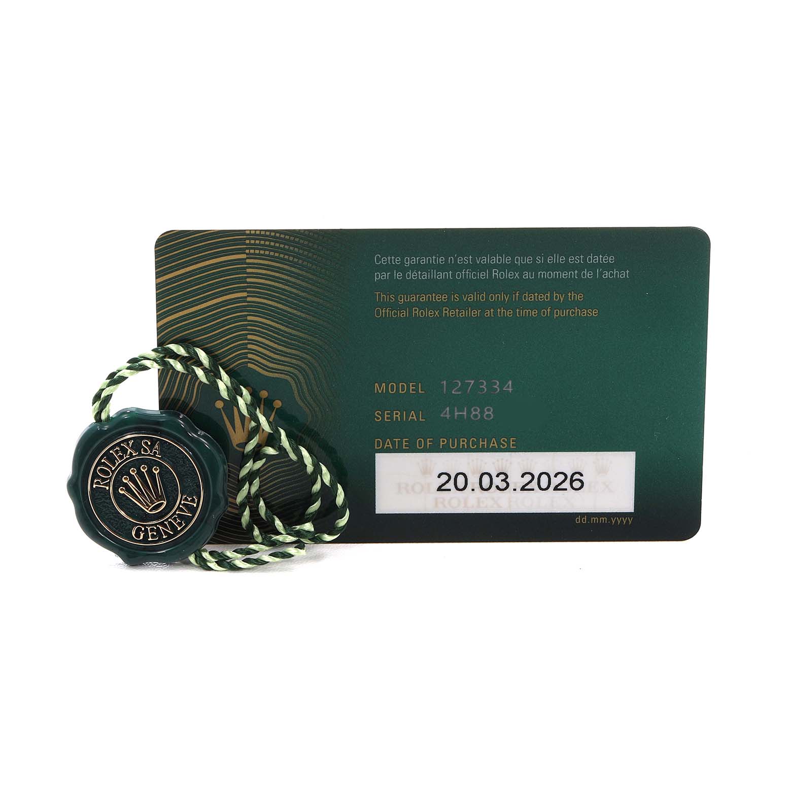 The Land‑Dweller model by Rolex is shown with a guarantee card and a green tag.