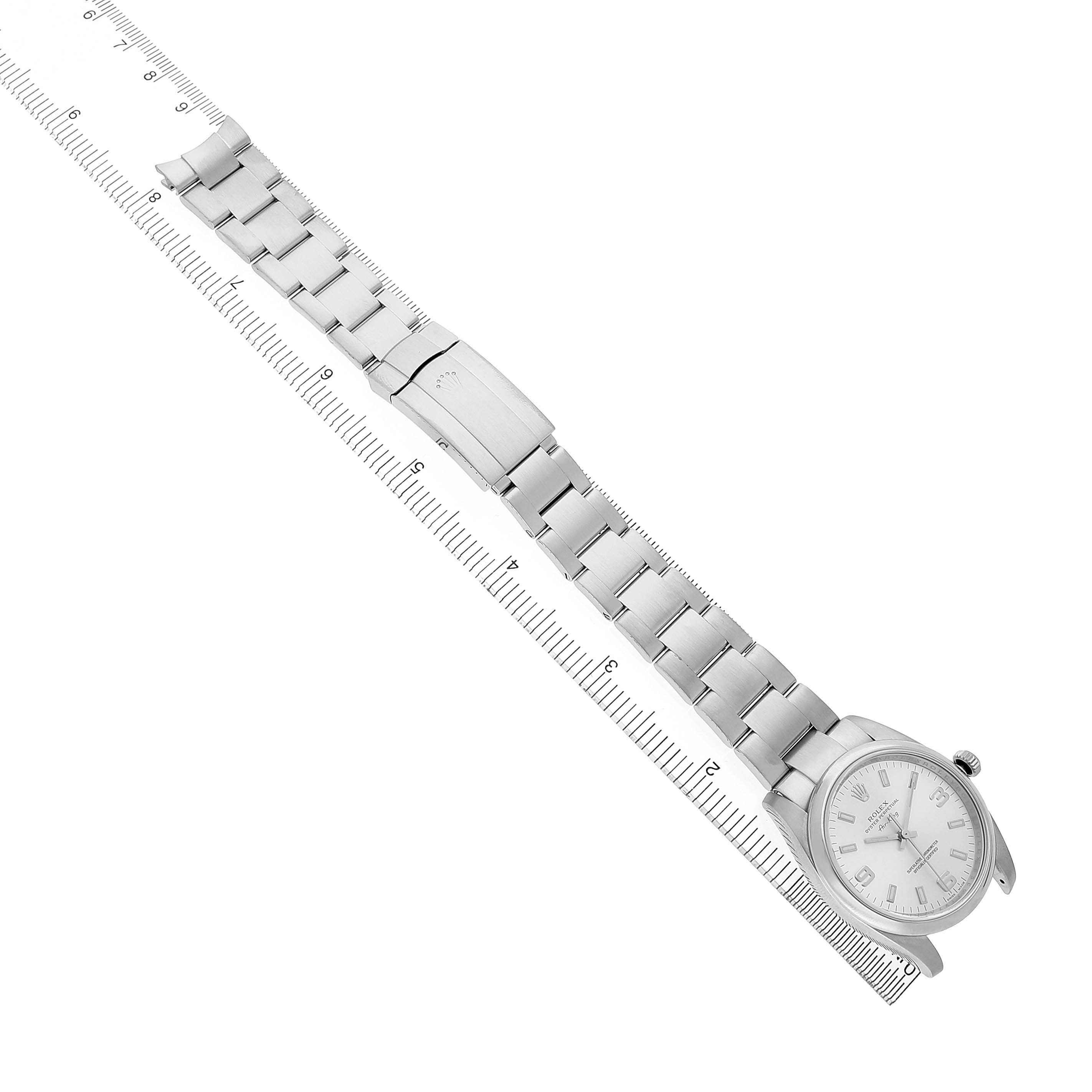 The Rolex Air-King 114200 Men's Stainless Steel Silver Dial watch is shown from a top-down angle, featuring the full bracelet and clasp laid out along a ruler.