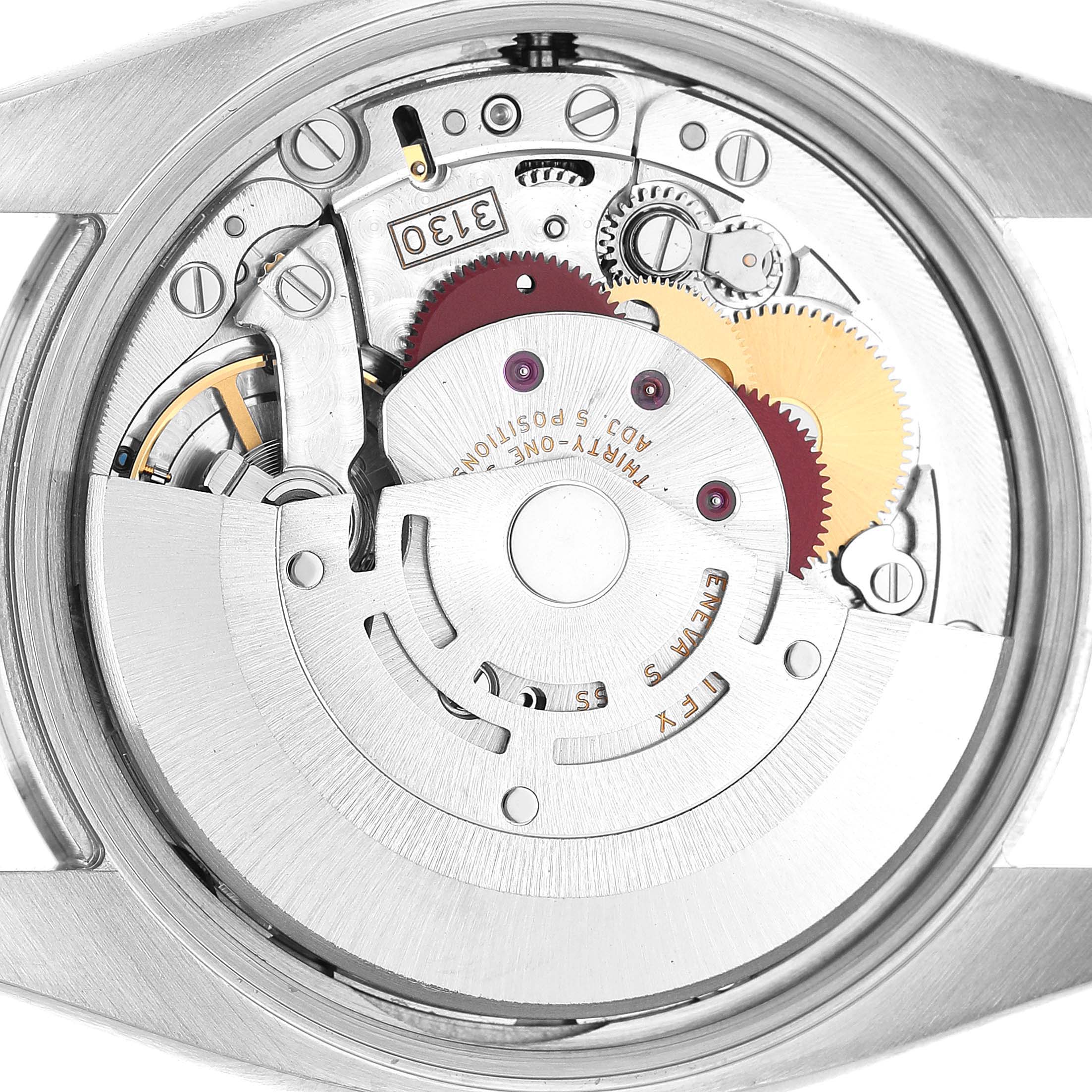 The image shows the movement of a Rolex Air-King 114200 Men's Stainless Steel Silver Dial watch viewed from the back, highlighting gears and mechanisms.