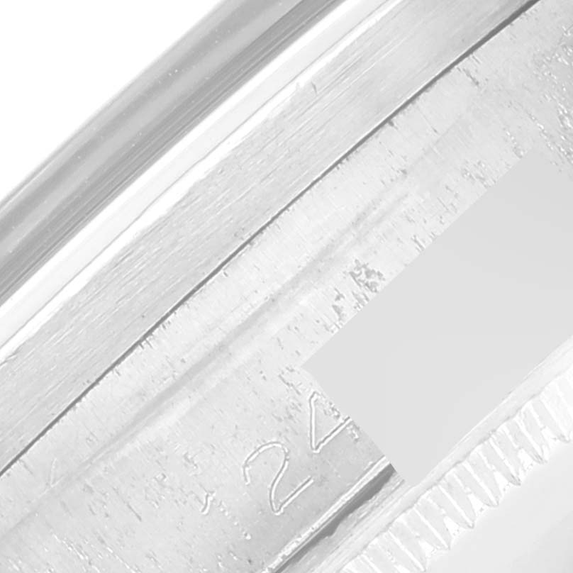 This image shows a close-up side view of a Rolex Vintage Collection 1007 Men's Stainless Steel Black Dial 1007 Men's Stainless Steel Black Dial watch, focusing on the engraved serial number and edge of the bezel.