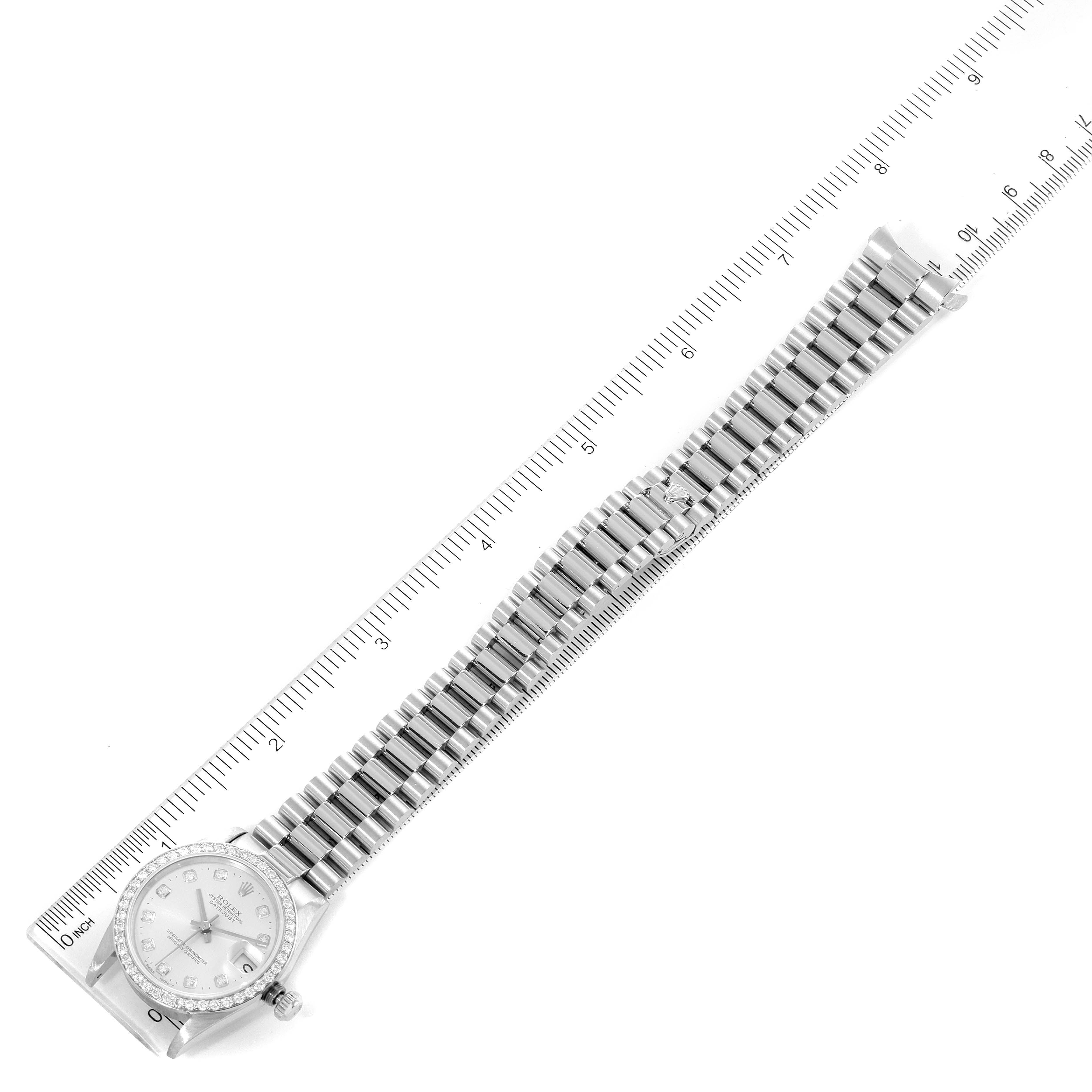 The image shows a top-down view of a Rolex President 68286 Women
s Platinum Silver Dial 68286 Women
s Platinum Silver Dial model watch with a full-length bracelet laid next to a ruler.