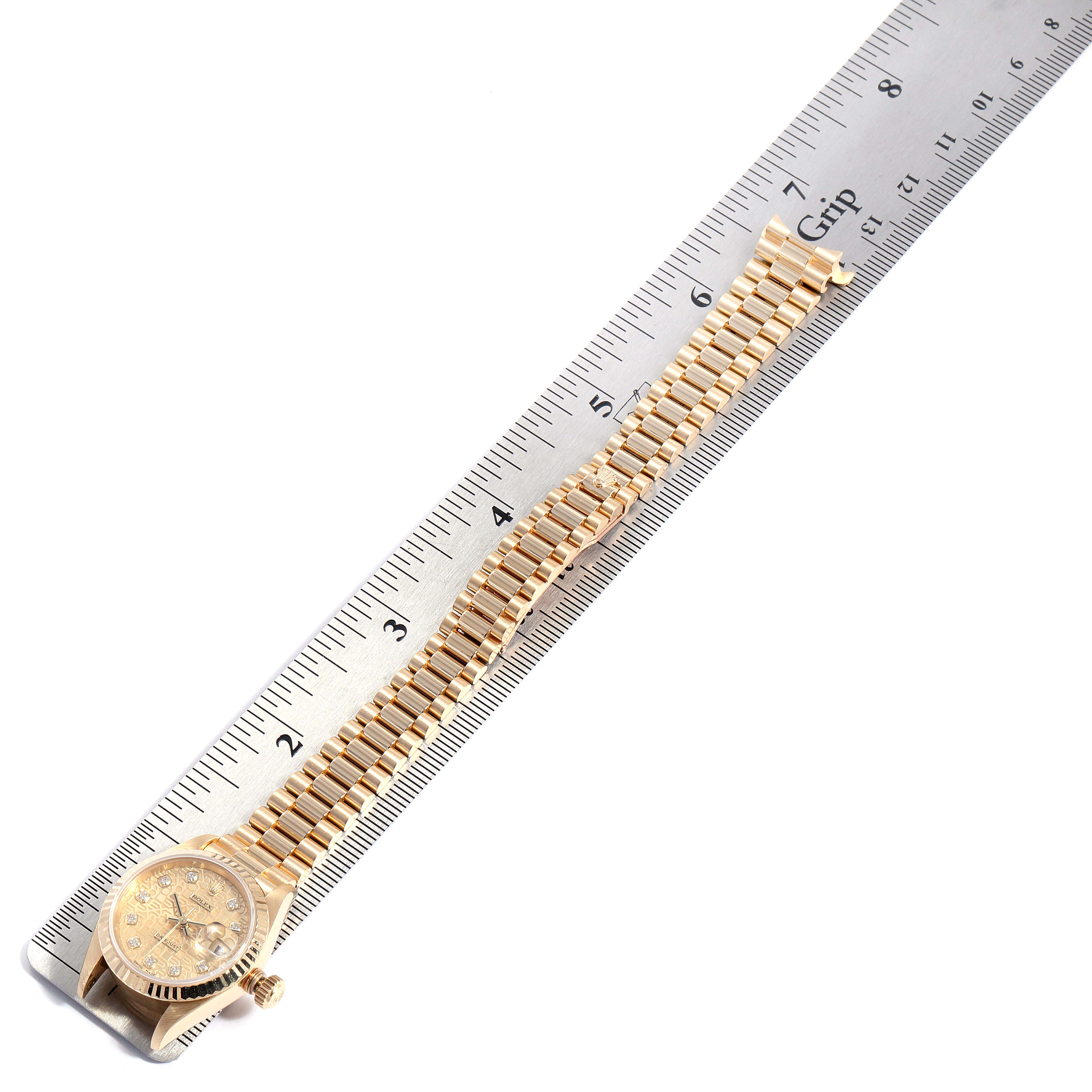 The Rolex President 79178 Women
s Yellow Gold Champagne Dial 79178 Women
s Yellow Gold Champagne Dial model watch is shown from above, displaying its face and full gold bracelet alongside a ruler for measurement.