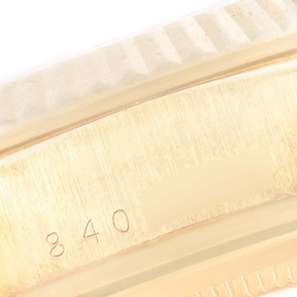 The image shows a close-up view of the side of a Rolex President 18038 Men
s Yellow Gold Champagne Dial 18038 Men
s Yellow Gold Champagne Dial model watch, displaying part of its fluted bezel and engraved numbers.