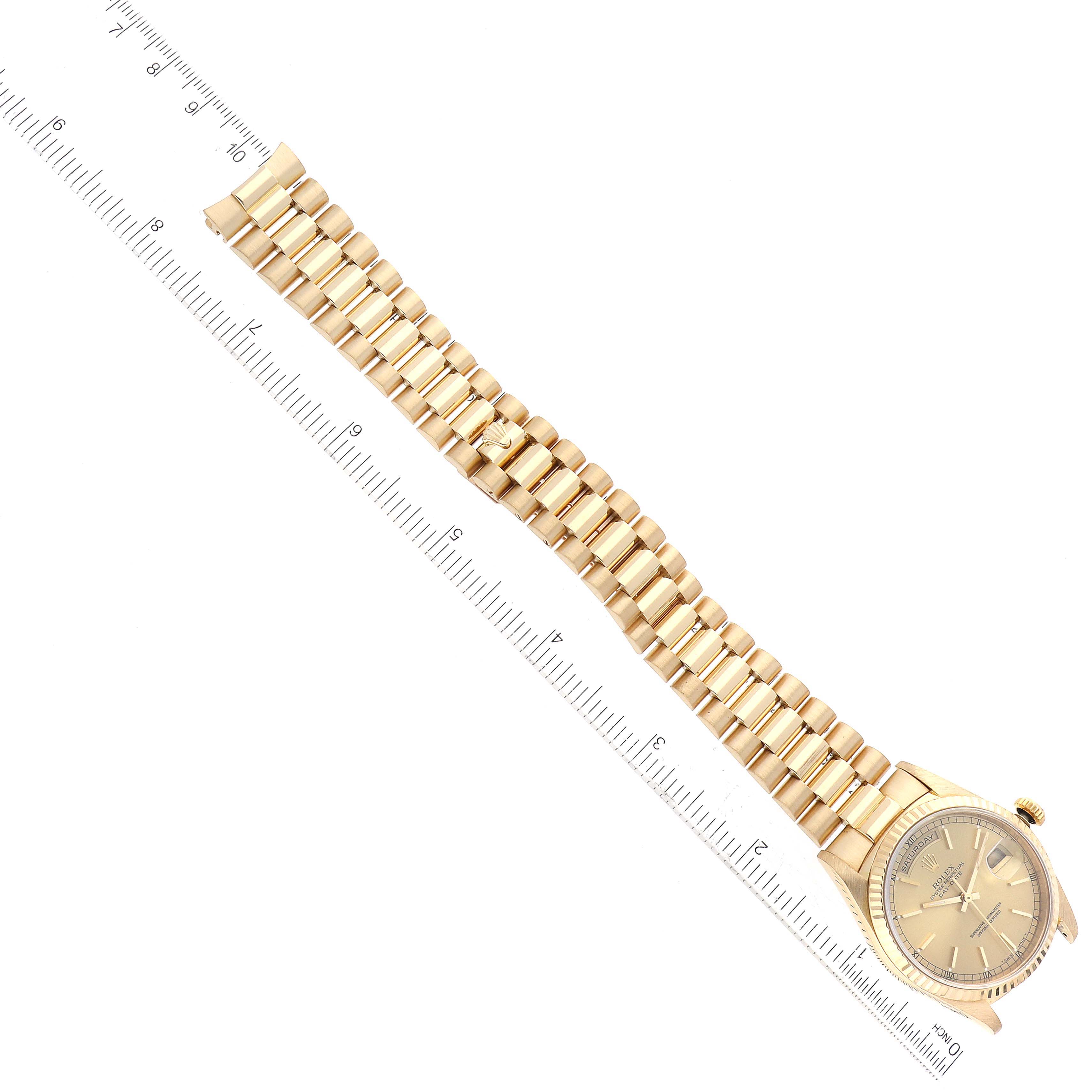 The image shows a top-down view of the Rolex President 18238 Men
s Yellow Gold Champagne Dial 18238 Men
s Yellow Gold Champagne Dial model watch, including its full band and face, next to a measuring ruler.