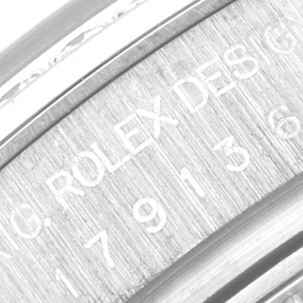 This close-up image shows the engraved inner bezel of a Rolex President 179136 Women's Platinum Silver Dial 179136 Women's Platinum Silver Dial watch, displaying part of the serial number and the "ROLEX DESIGN" engraving.