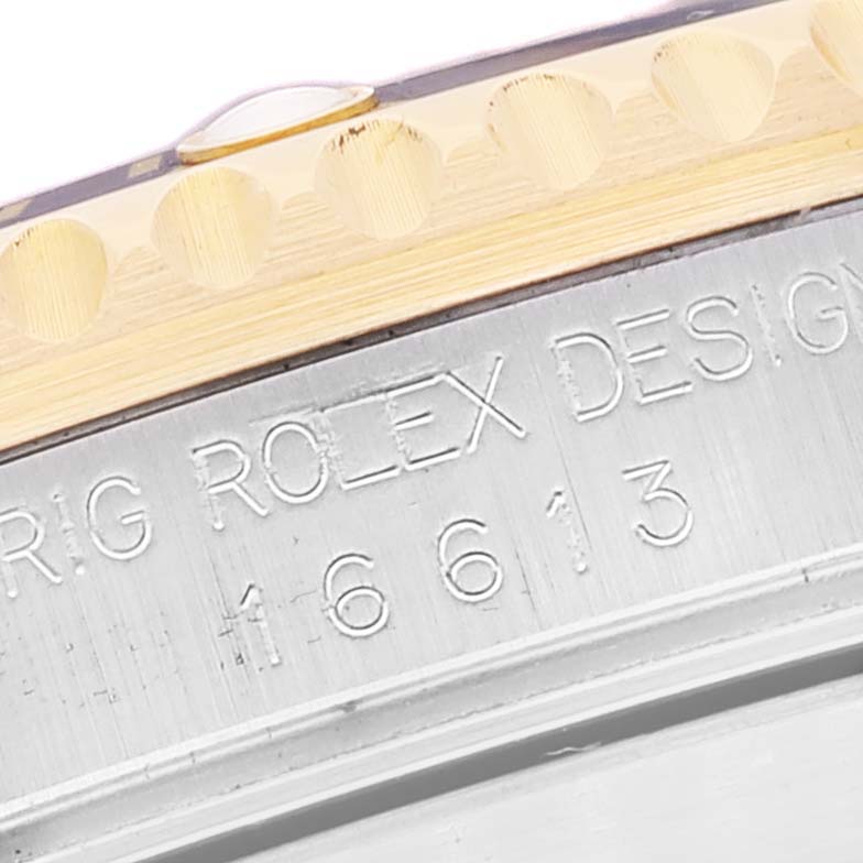 The image shows a close-up angle of the bezel and case side of the Rolex Submariner 16613 Men's Steel and Gold (two tone) Champagne Dial 16613 Men's Steel and Gold (two tone) Champagne Dial 16613, highlighting the engravings.