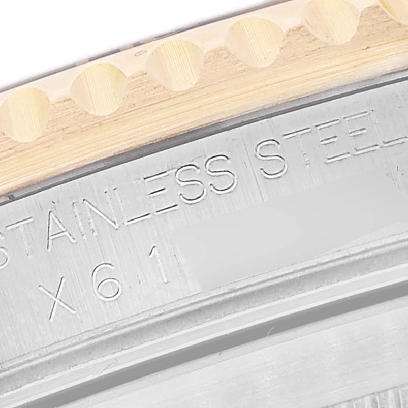 This image shows a close-up of the side engraving on the case of a Rolex Submariner 16613 Men's Steel and Gold (two tone) Champagne Dial 16613 Men's Steel and Gold (two tone) Champagne Dial watch, highlighting the stainless steel text and some serial numbers.