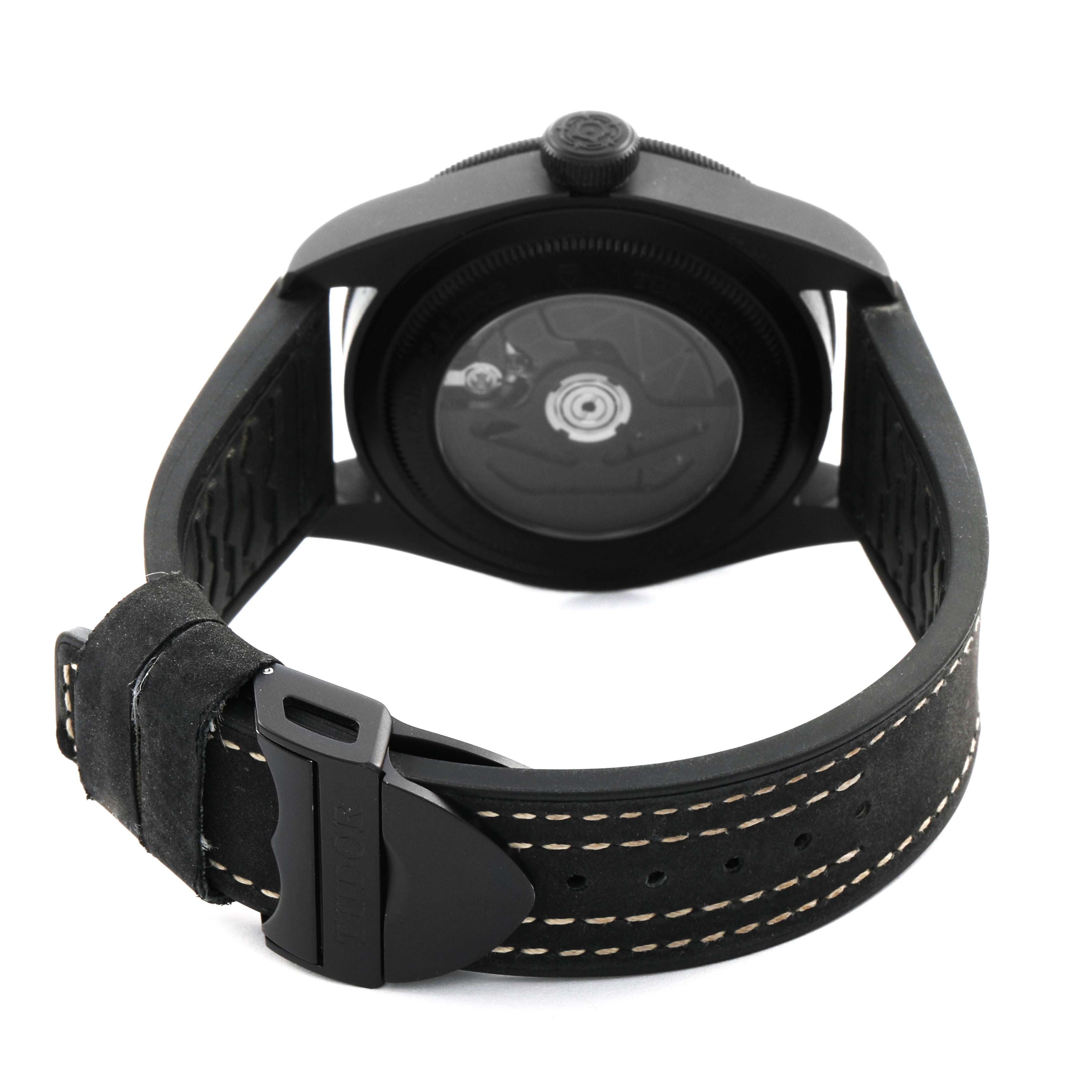 The Heritage Black Bay by Tudor is shown from the back, displaying the case back and strap with a visible buckle and contrast stitching.