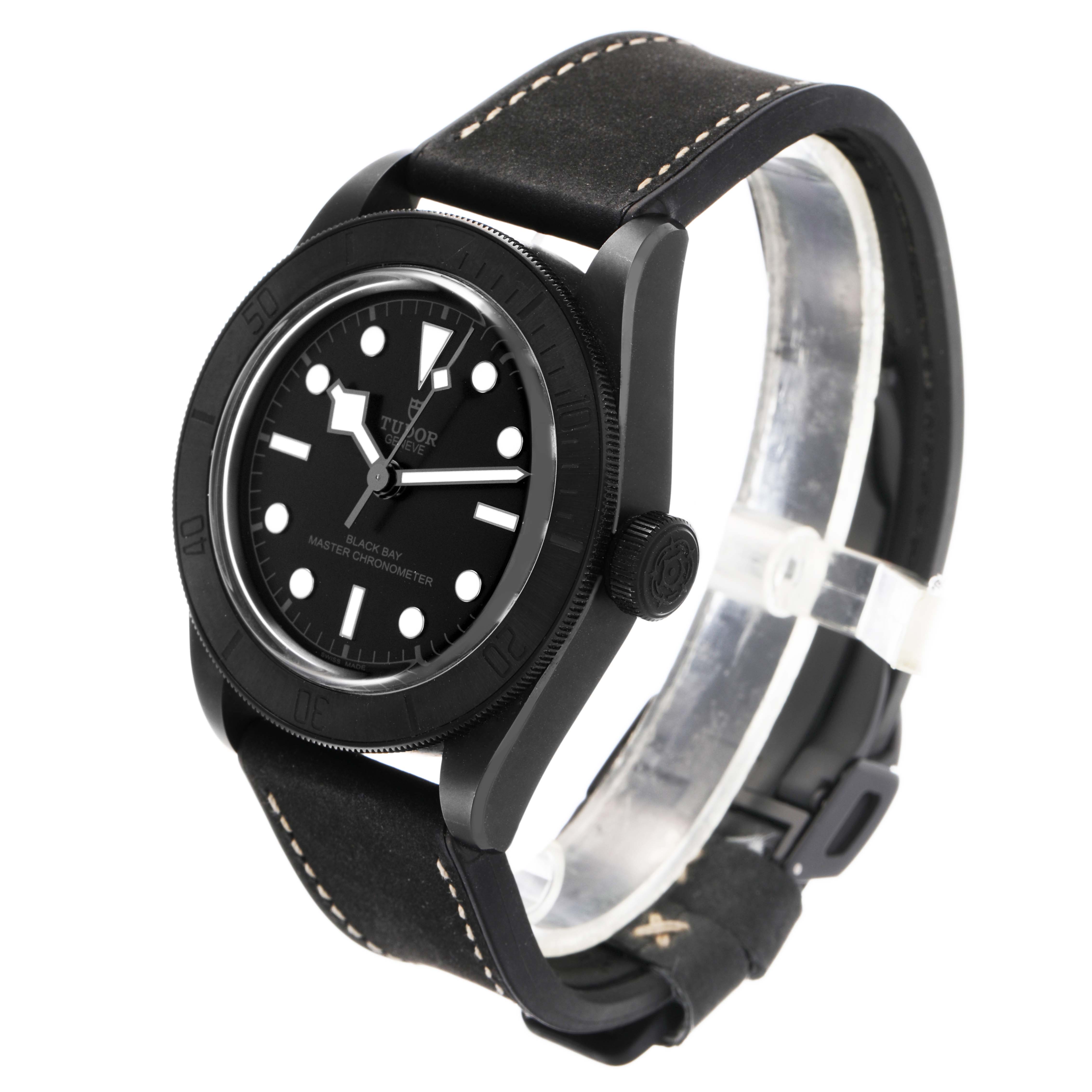 The Tudor Heritage Black Bay 79210 Men's Ceramic Black Dial watch is shown from a front-side angle, highlighting its black dial, case, bezel, and leather strap.