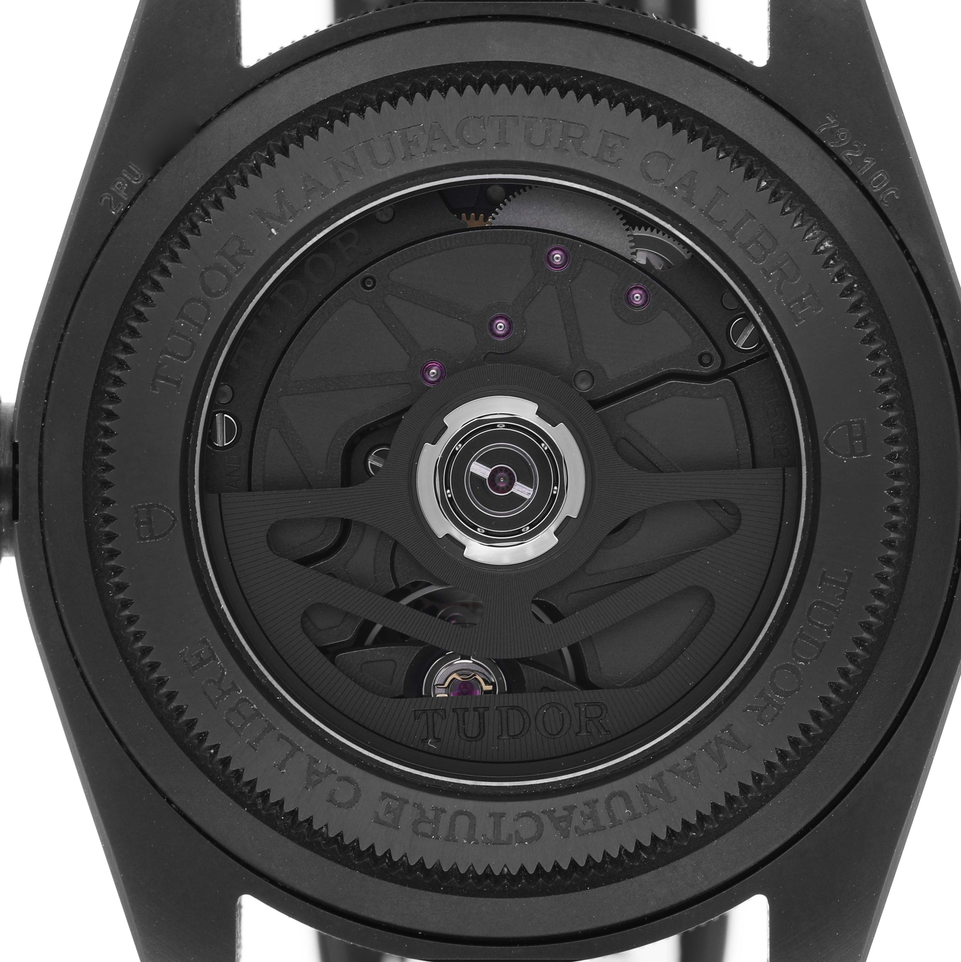 The image shows the caseback view of the Tudor Heritage Black Bay 79210 Men's Ceramic Black Dial, revealing the movement and caliber details.