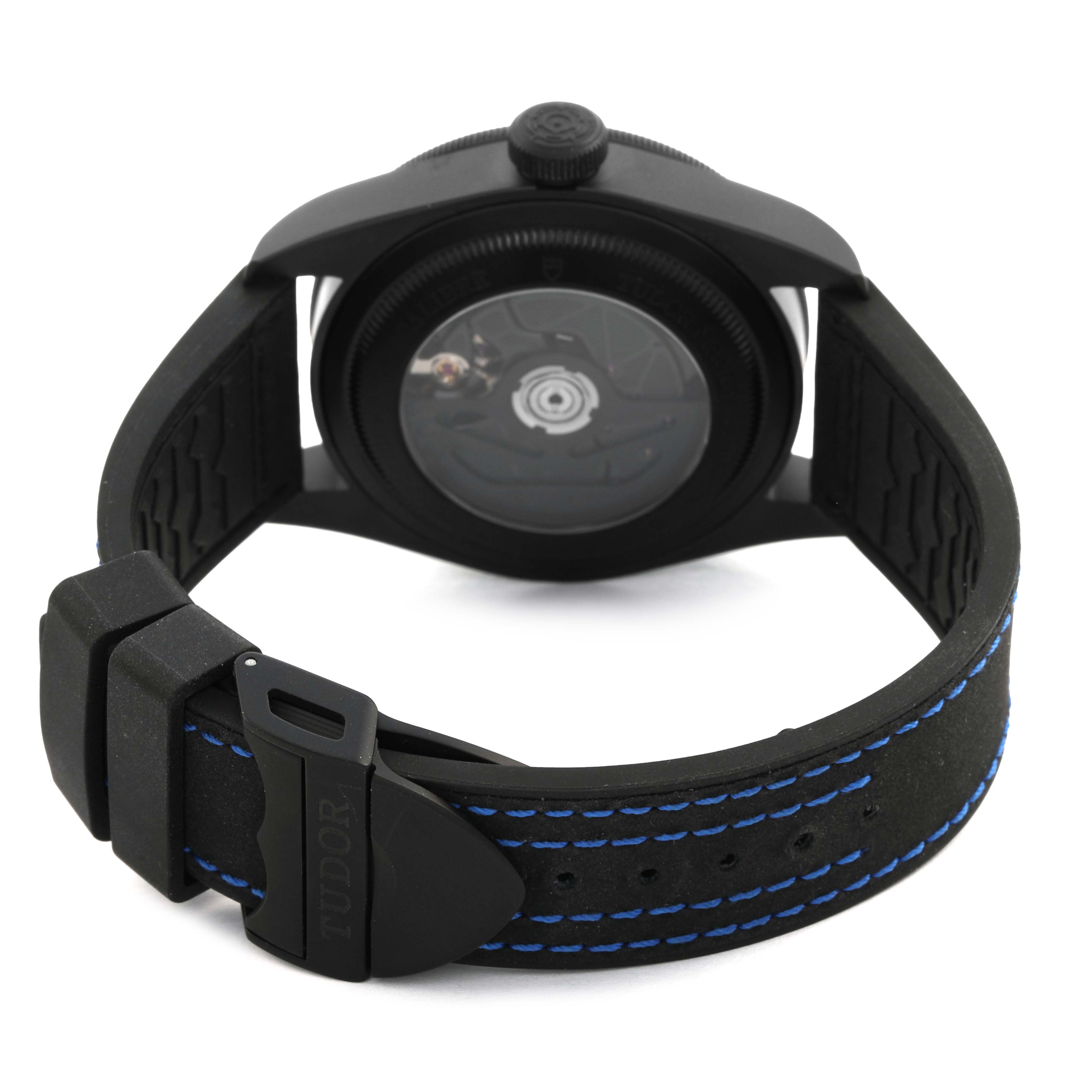 The Tudor Heritage Black Bay 79210 Men's Ceramic Blue Dial watch is shown from the back, highlighting the strap, buckle, and caseback.