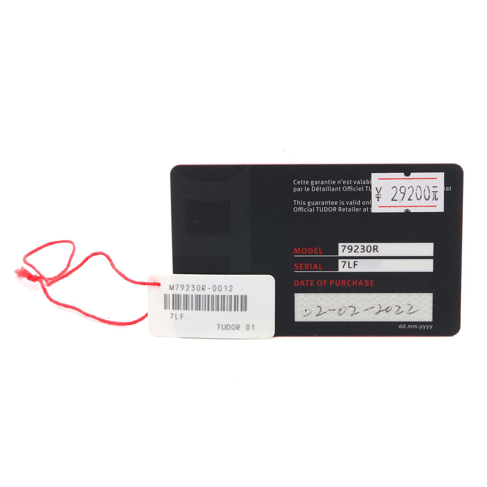 The image shows a Tudor Heritage Black Bay 79230R Men's Stainless Steel Black Dial 79230R Men's Stainless Steel Black Dial warranty card with model and serial numbers, alongside a red string tag.