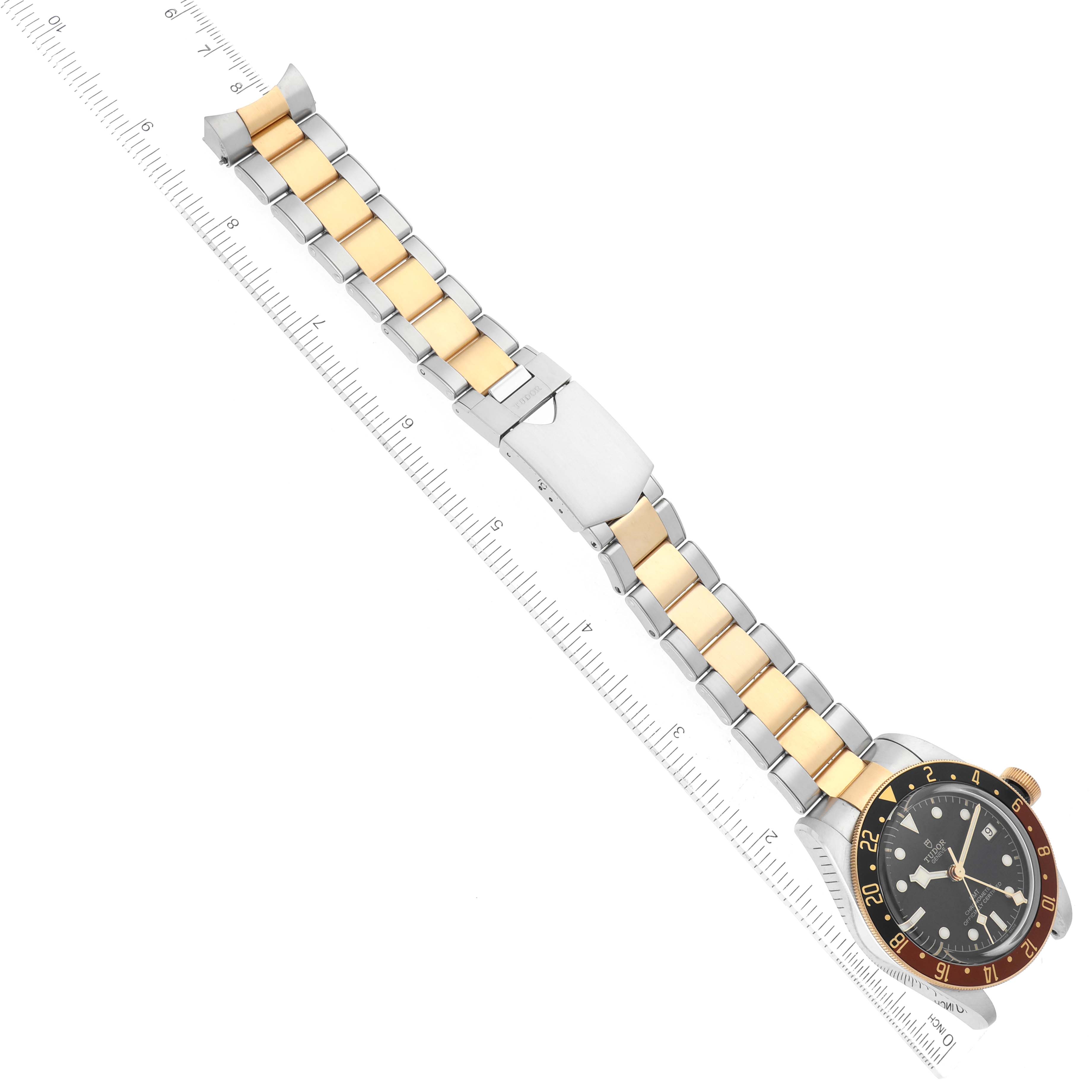 The image shows a top view of a Tudor Heritage Black Bay 79833MN Men's Steel and Gold (two tone) Black Dial 79833MN Men's Steel and Gold (two tone) Black Dial watch with a two-tone metal bracelet and a ruler for scale.