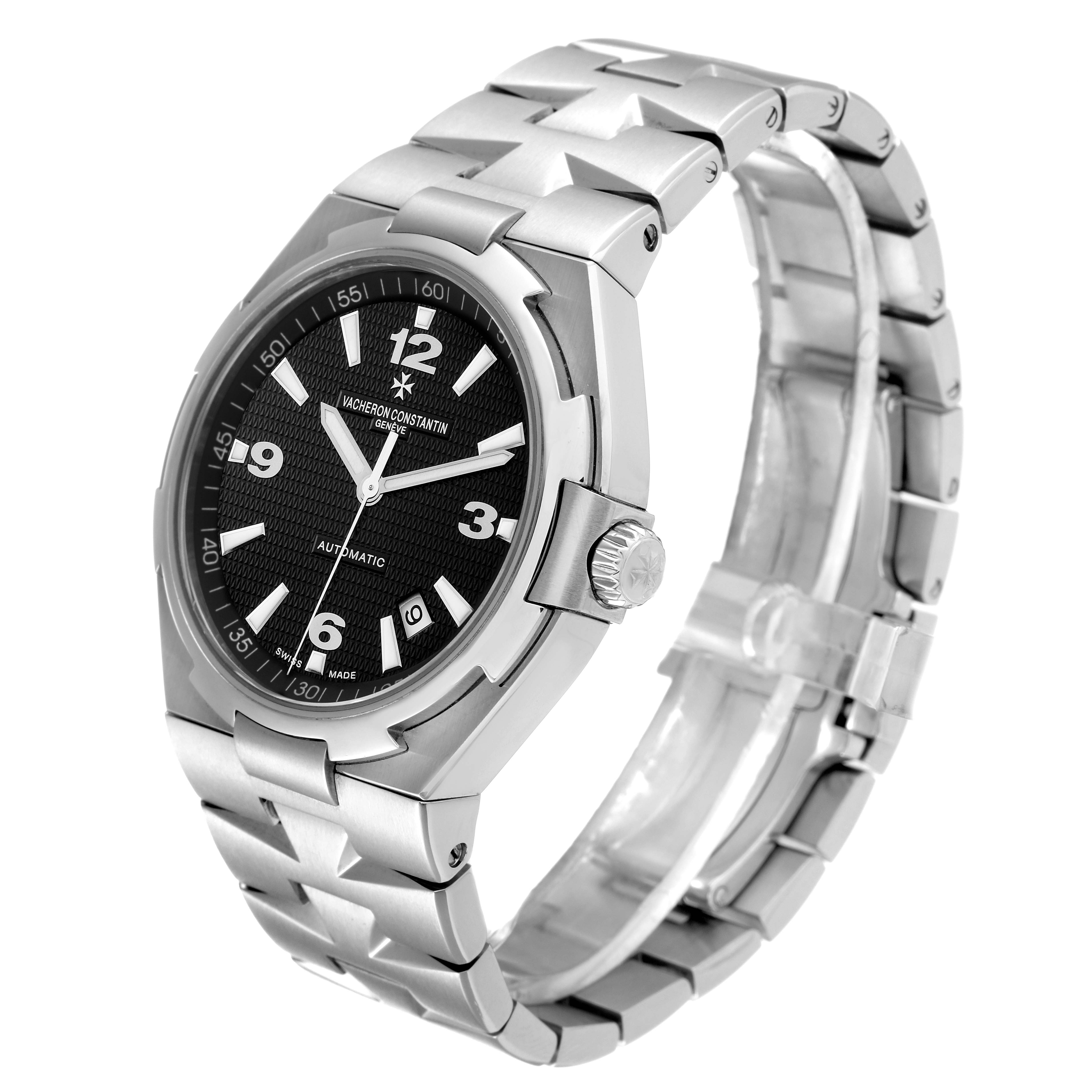 The image shows a Vacheron Constantin Overseas 47040/B01A-9094 Men's Stainless Steel Black Dial 47040/B01A-9094 Men's Stainless Steel Black Dial model watch from a three-quarter angle, highlighting the face, crown, and metal bracelet.