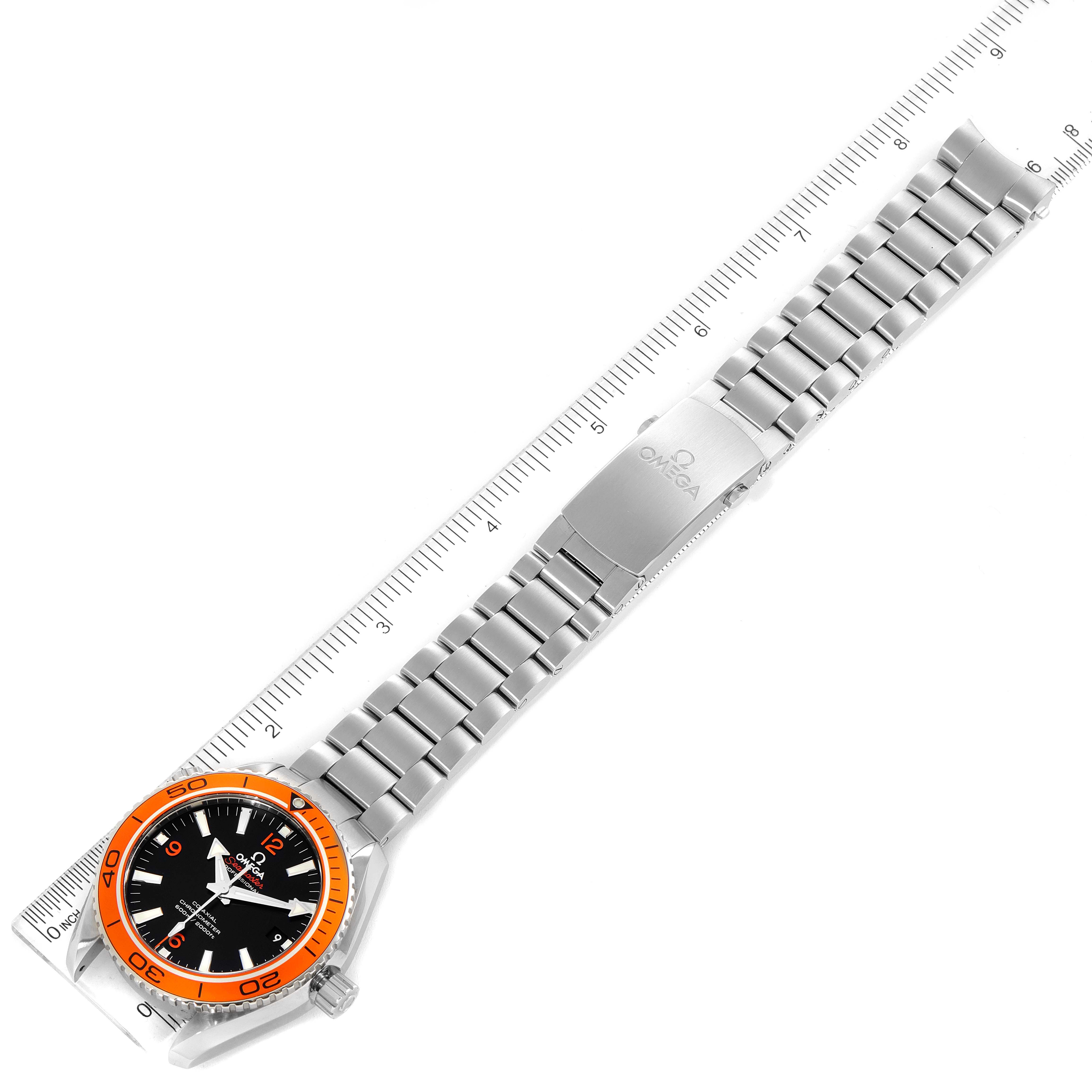 The image shows the top view of an Omega Planet Ocean 232.30.42.21.01.002 Men
s Stainless Steel Black Dial 232.30.42.21.01.002 Men
s Stainless Steel Black Dial watch, highlighting the bracelet, clasp, bezel, and case, alongside a ruler for scale.