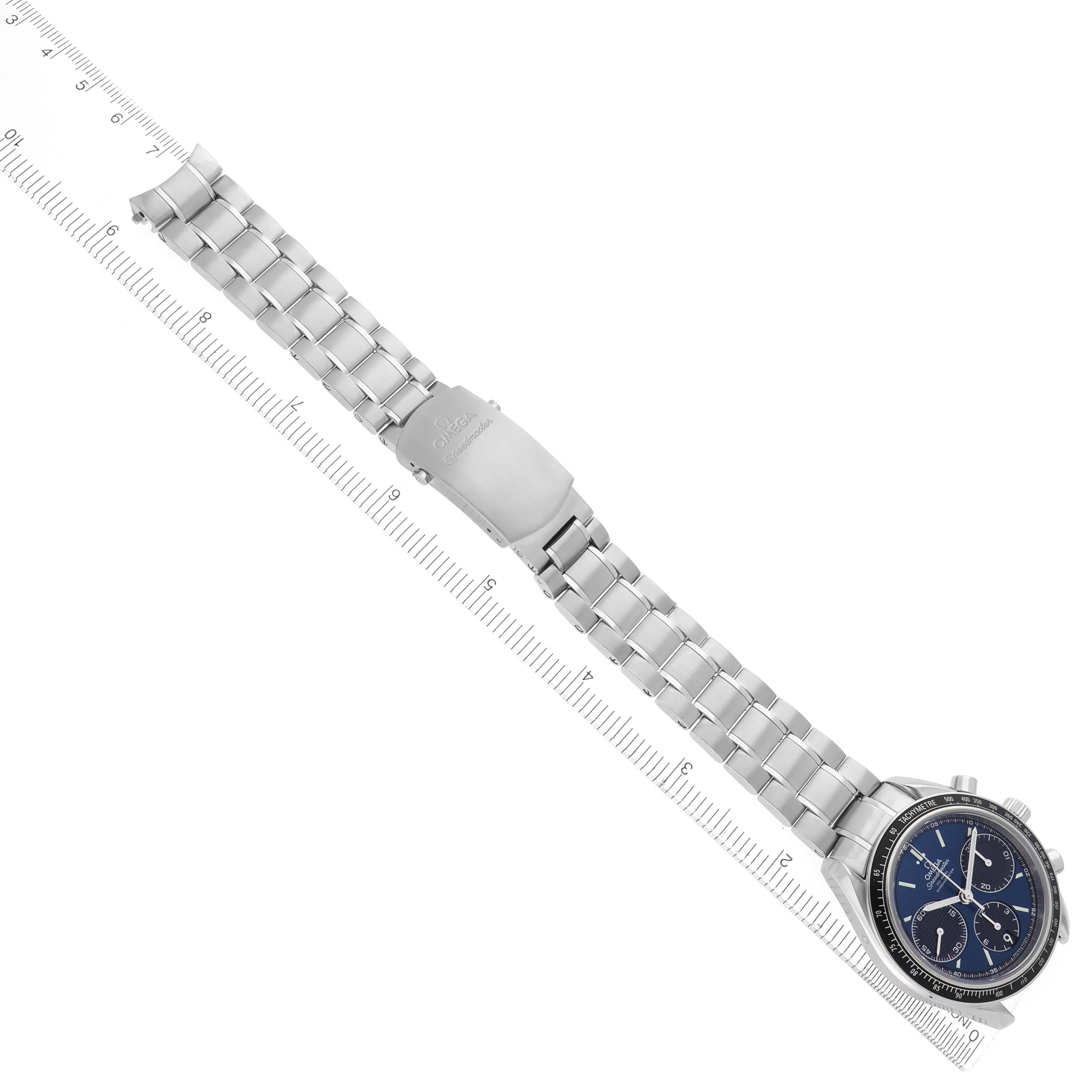 The Omega Speedmaster 326.30.40.50.03.001 Men's Stainless Steel Blue Dial 326.30.40.50.03.001 Men's Stainless Steel Blue Dial watch is shown from a top view, displaying the full band, clasp, and watch face aligned with a ruler.