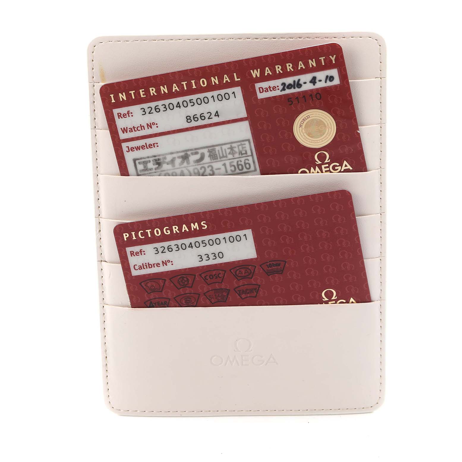 The image shows warranty and pictogram cards for an Omega Speedmaster 326.30.40.50.01.001 Men's Stainless Steel Black Dial 326.30.40.50.01.001 Men's Stainless Steel Black Dial, held in slots of a white cardholder.